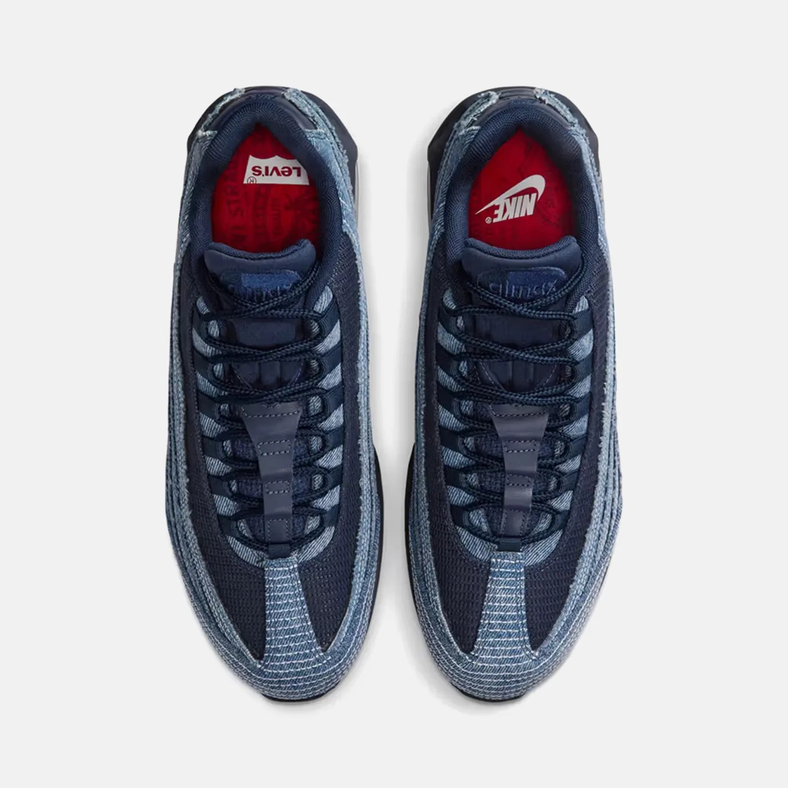 The red insoles of the Nike x Levi's Air Max 25. One features the Nike name and swoosh in white. The other features the Levi's logo in white. 