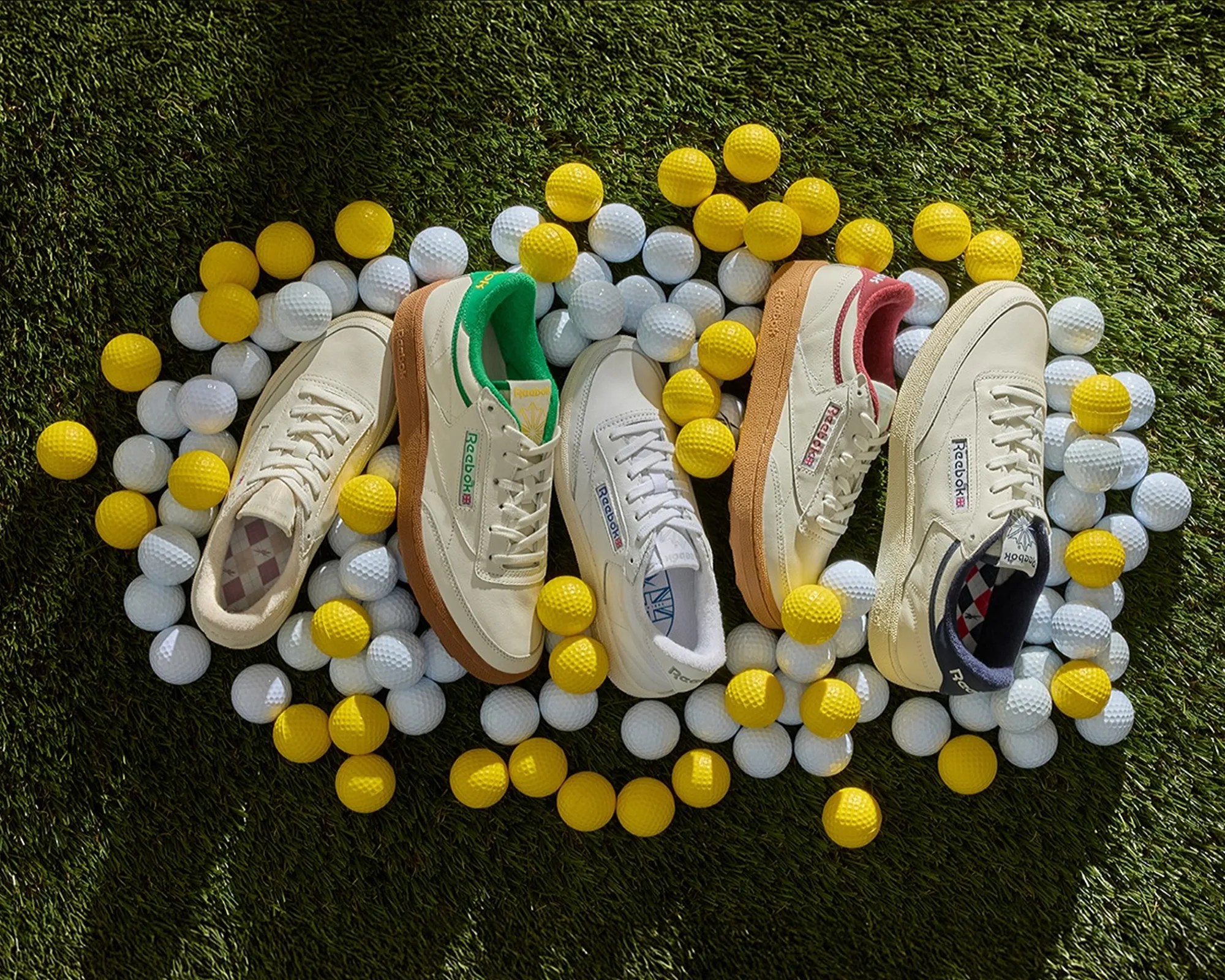 Reebok Club C Golf Shoes on turf surrounded by golf balls