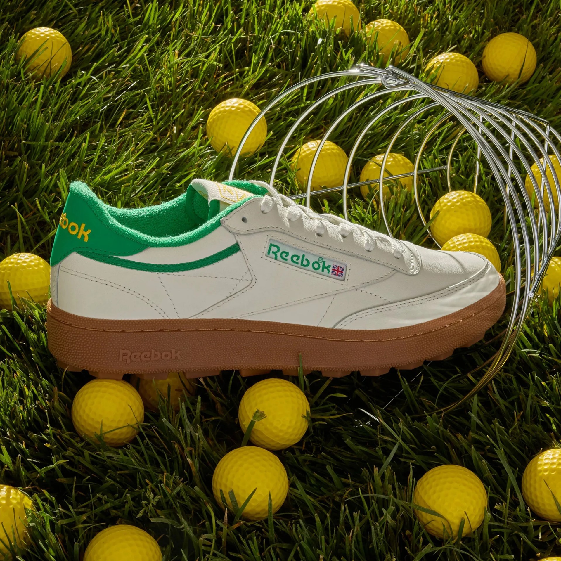 Reebok Club C Golf Shoe on grass with golf balls