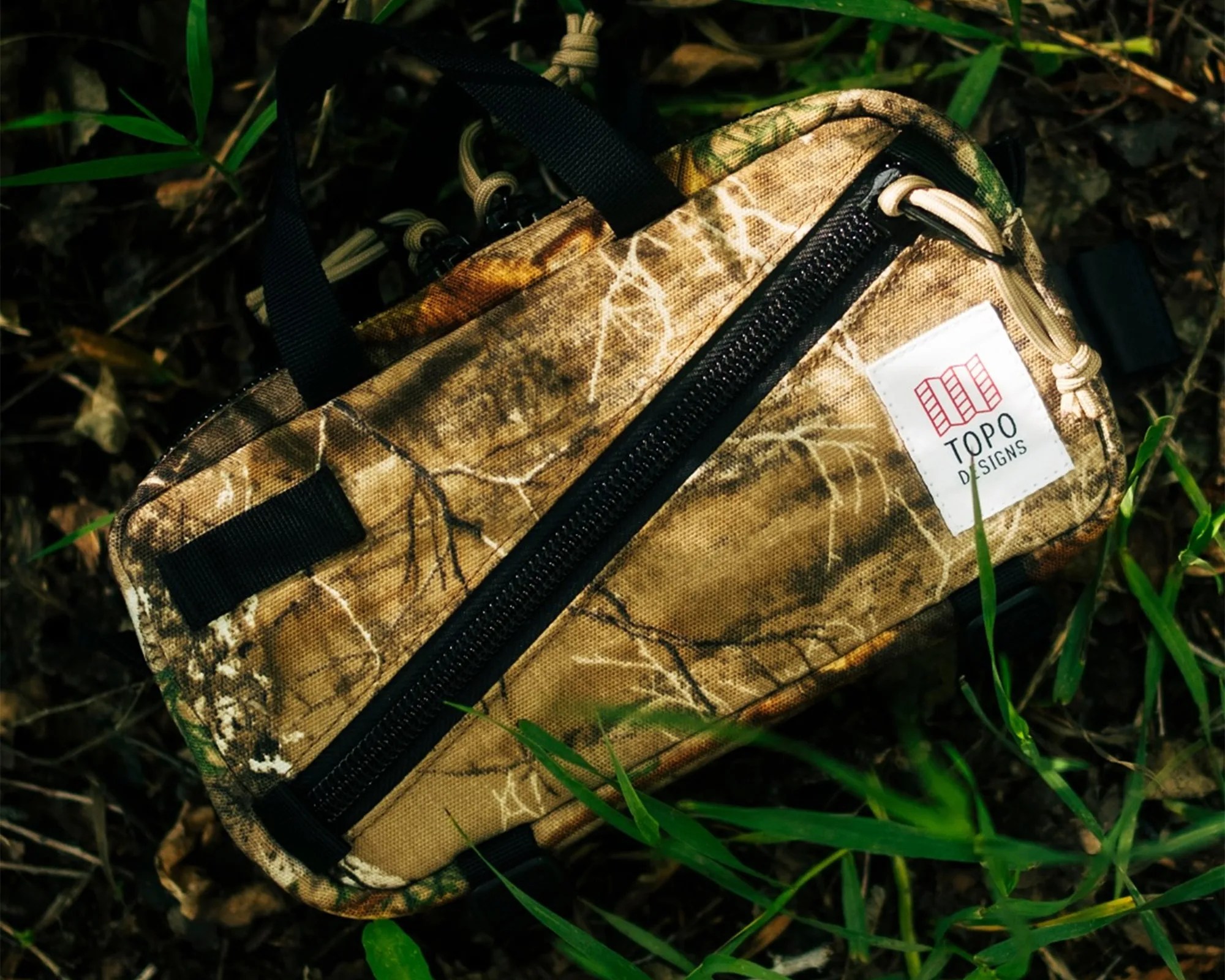 Topo Designs Forest Floor Camo EDC sling bag on forest floor
