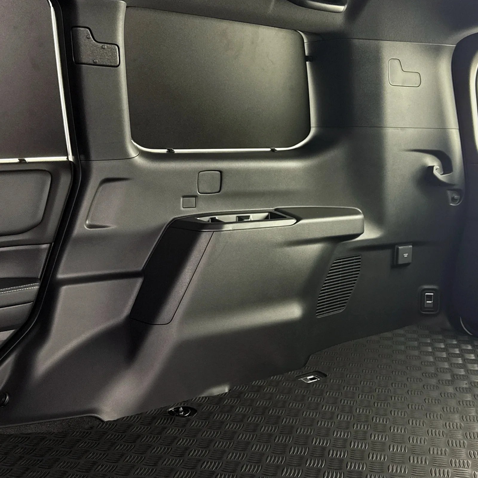 A side view of the rear cargo area of the Toyota Land Cruiser Commercial edition showing the windows covered in steel plates and the reinforced flooring.