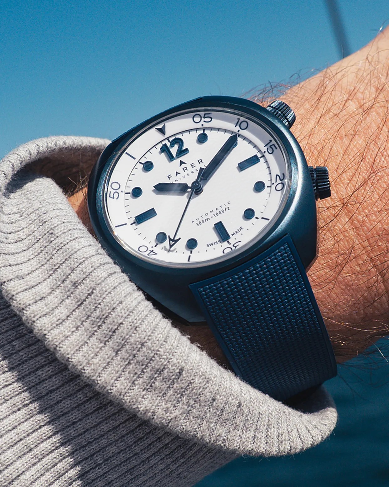 a white dial dive watch on a man's wrist