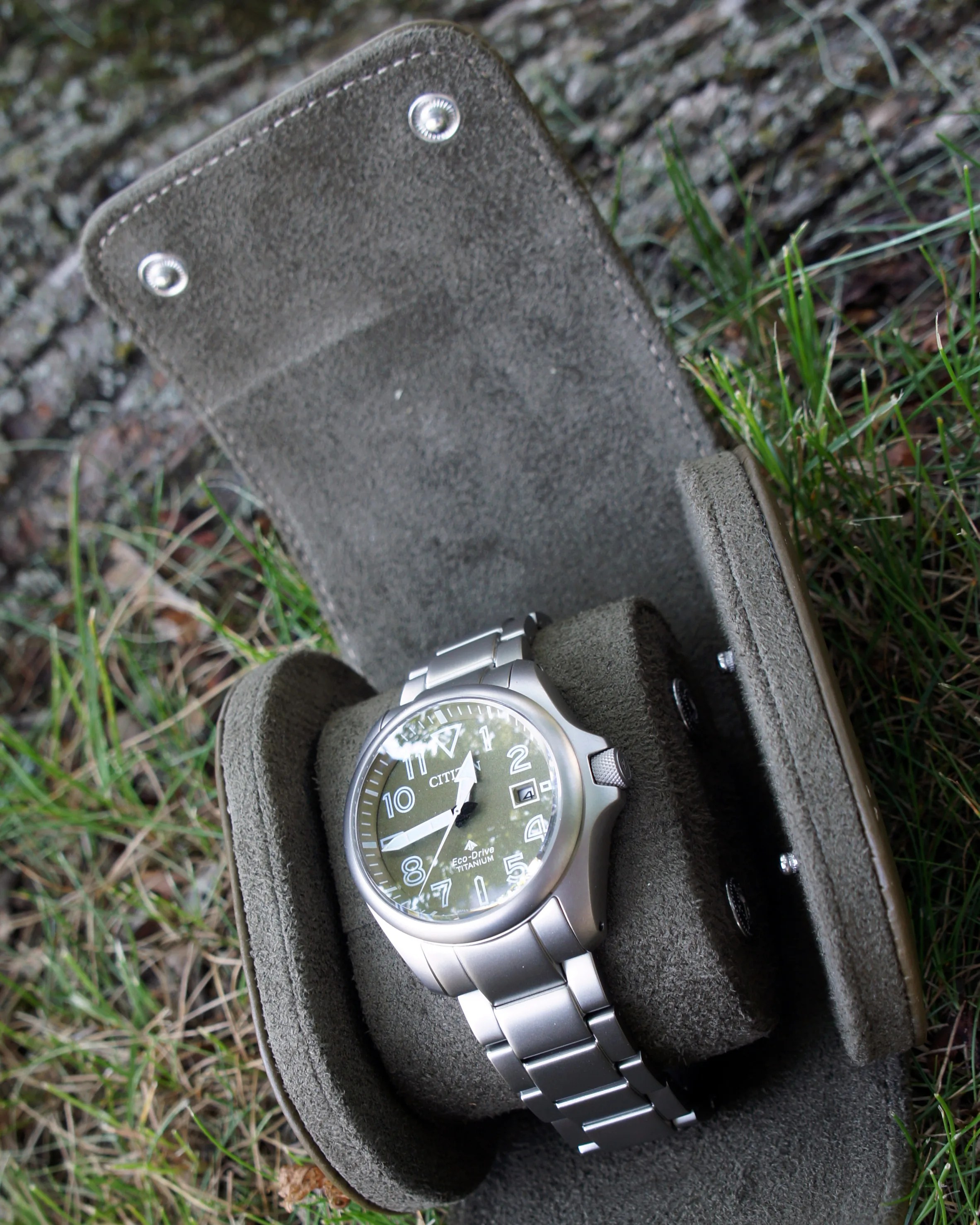 a green Citizen watch in a leather watch roll