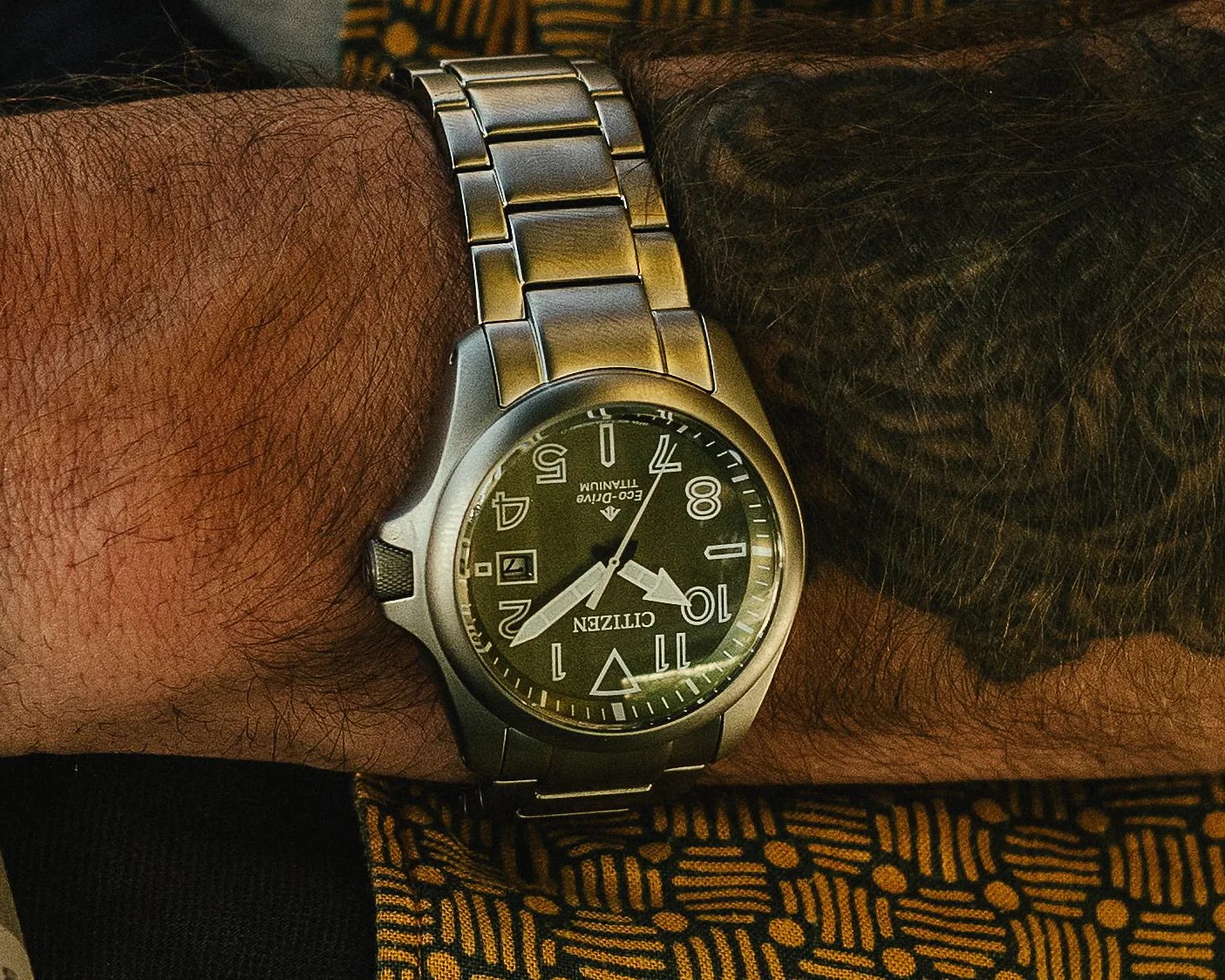 a green Citizen watch on a man's wrist