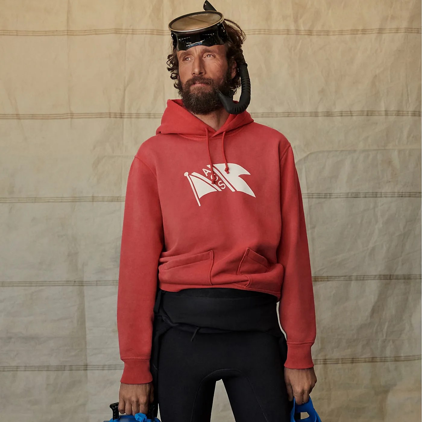 a man in a wet suit and a red hoodie