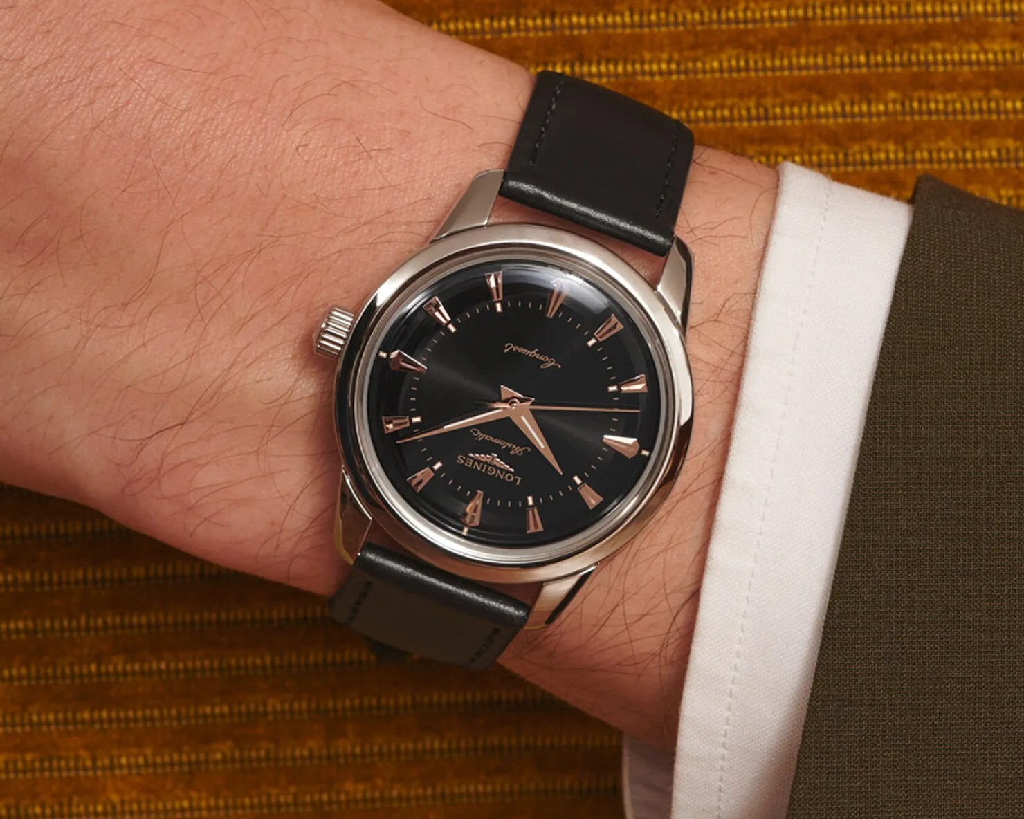 a black Longines watch on a man's wrist