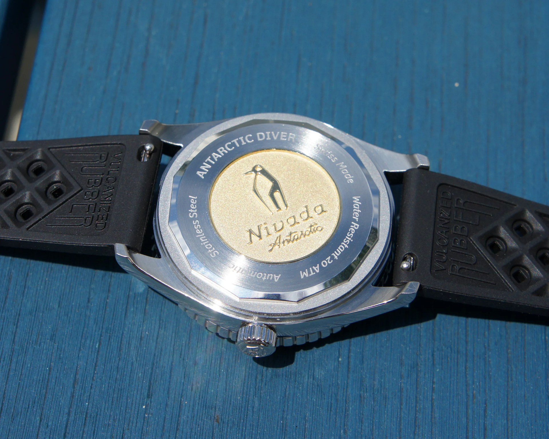 the case back of a Nivada watch with a penguin on it