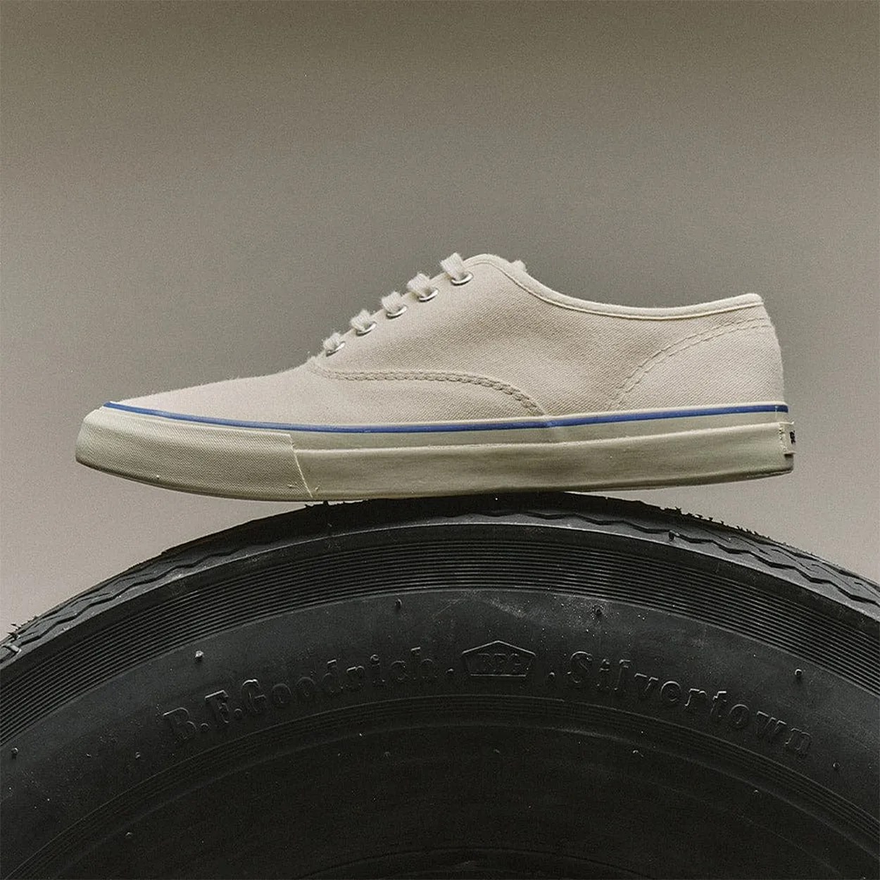 a white canvas sneaker on a tire