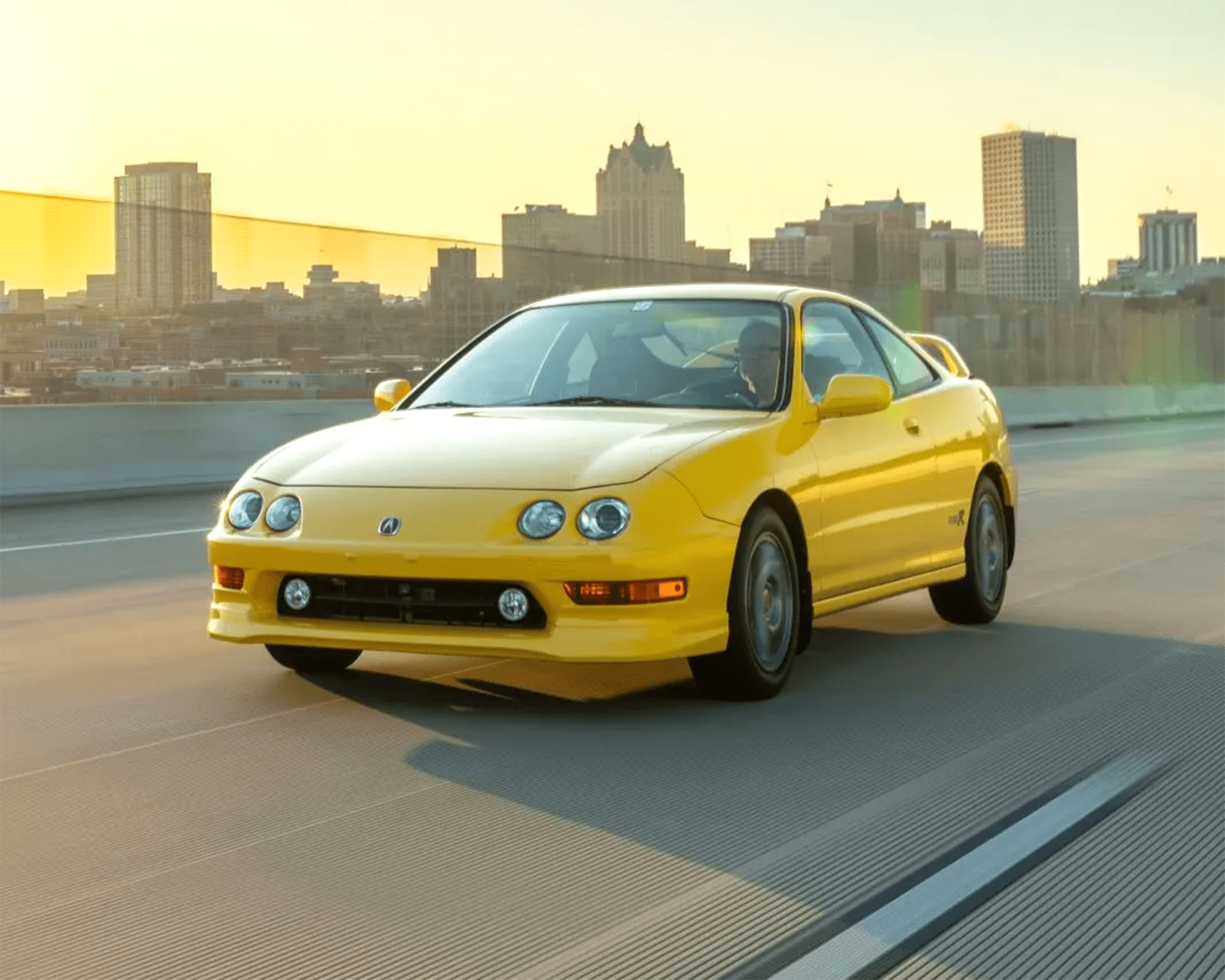 a photo of a yellow acura integra type r driving