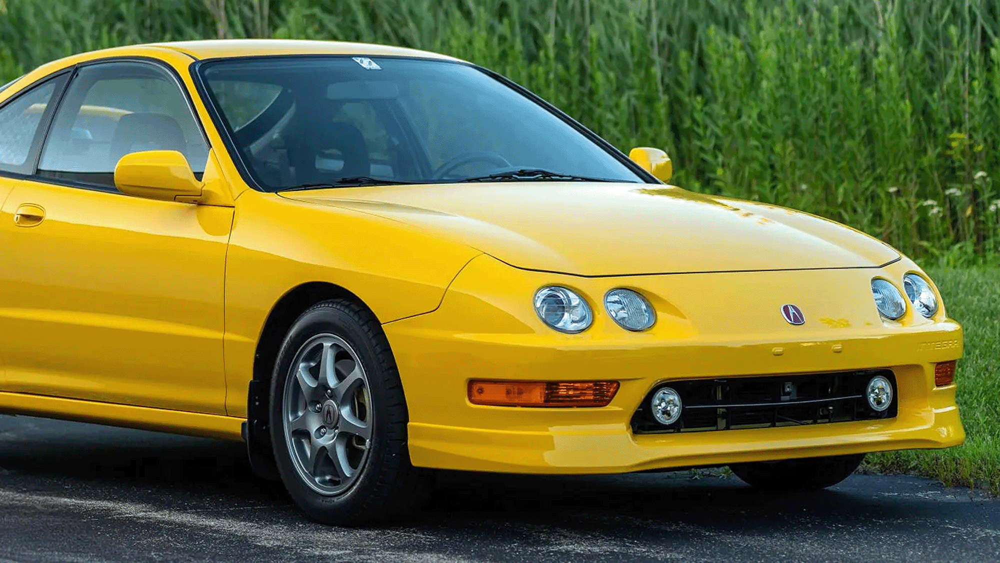 close-up of a yellow acura integra type r green backdrop