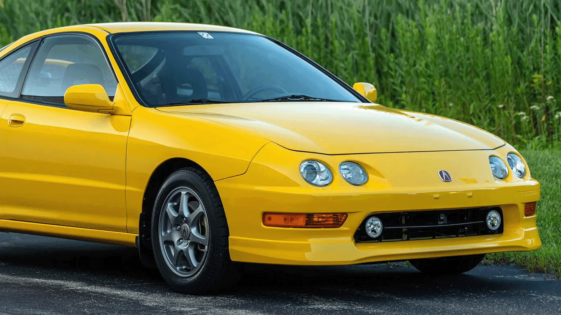 close-up of a yellow acura integra type r green backdrop