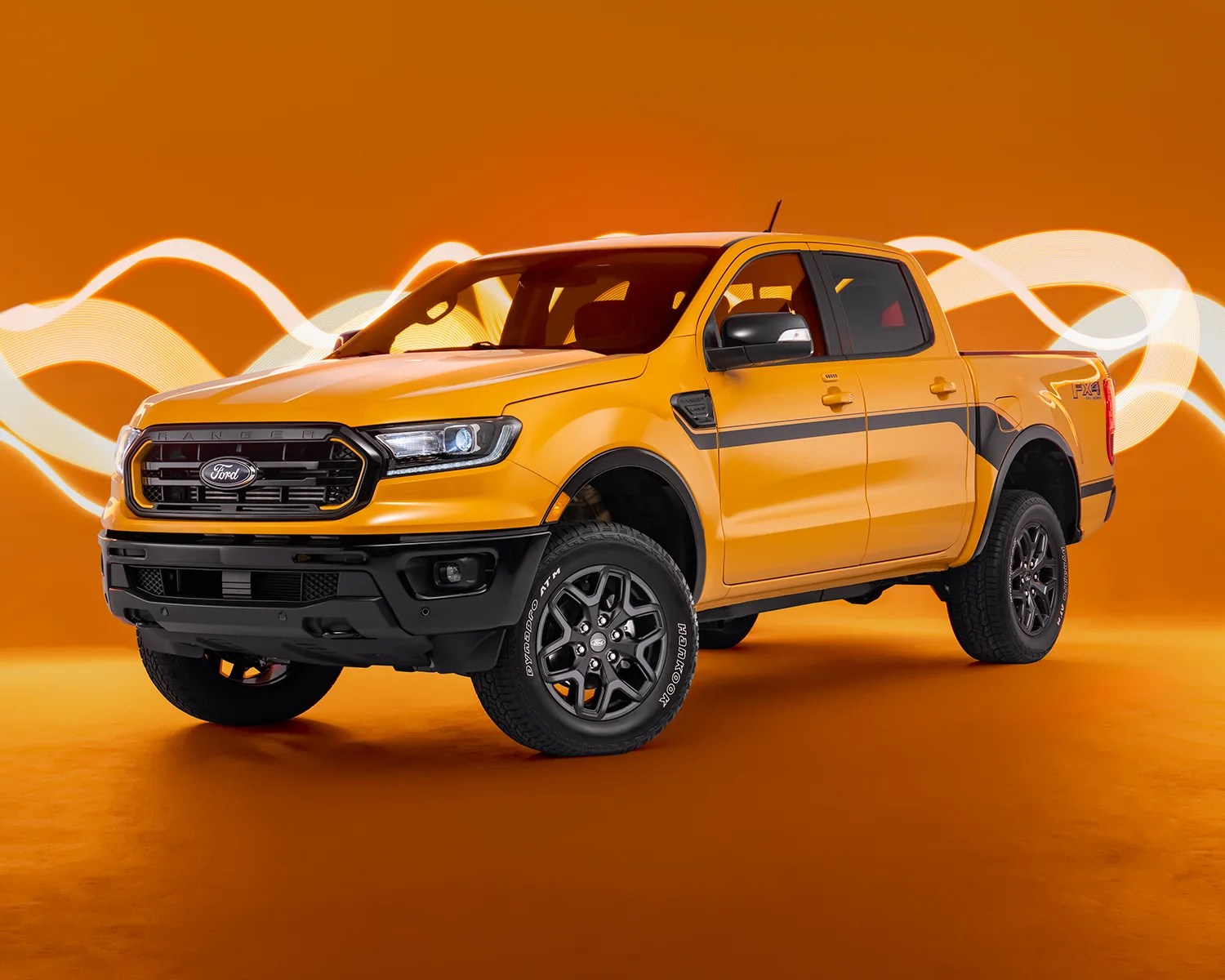 a photo of a yellow ford ranger on a studio backdrop