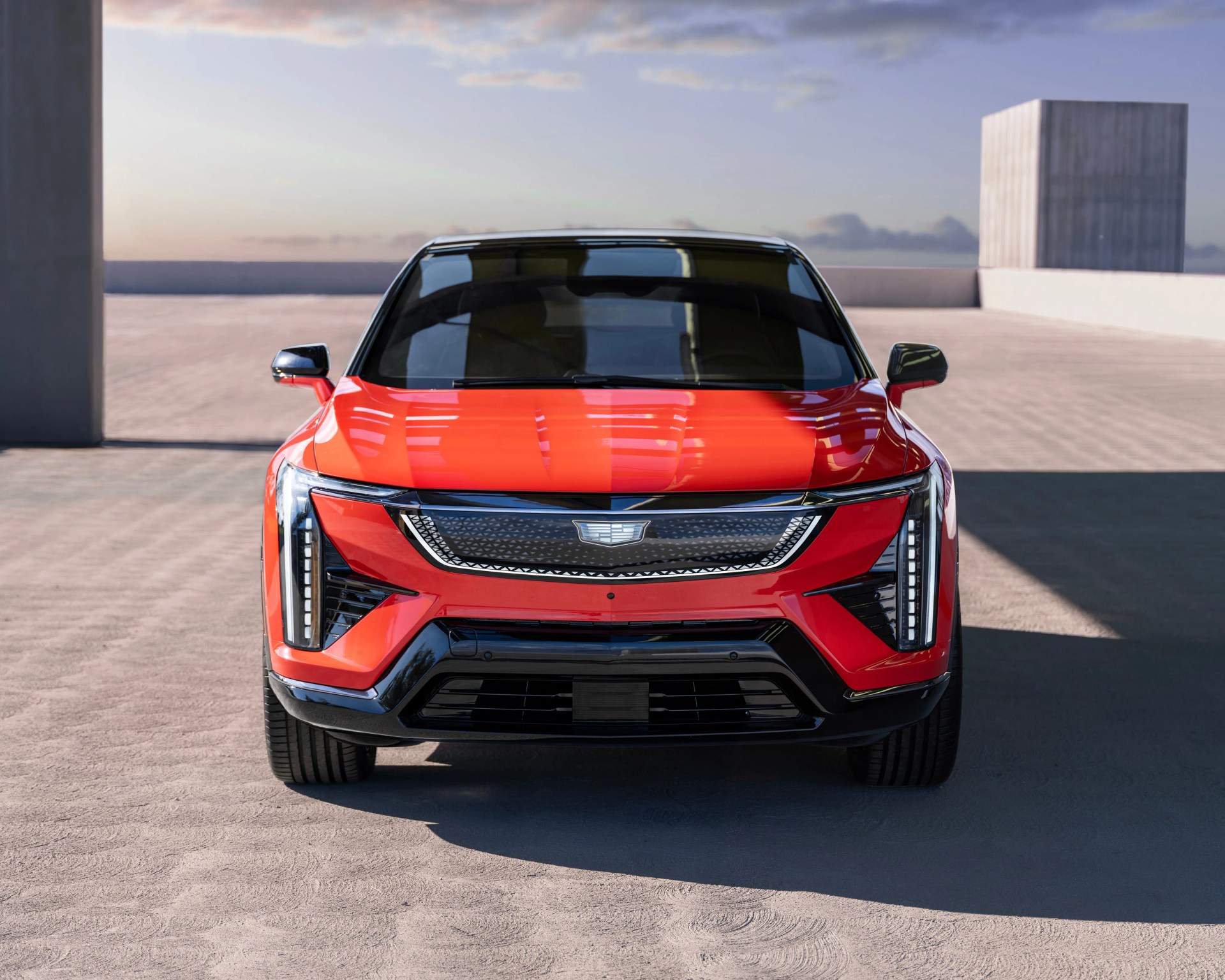 orange cadillac electric car head-on shot brutalist backdrop
