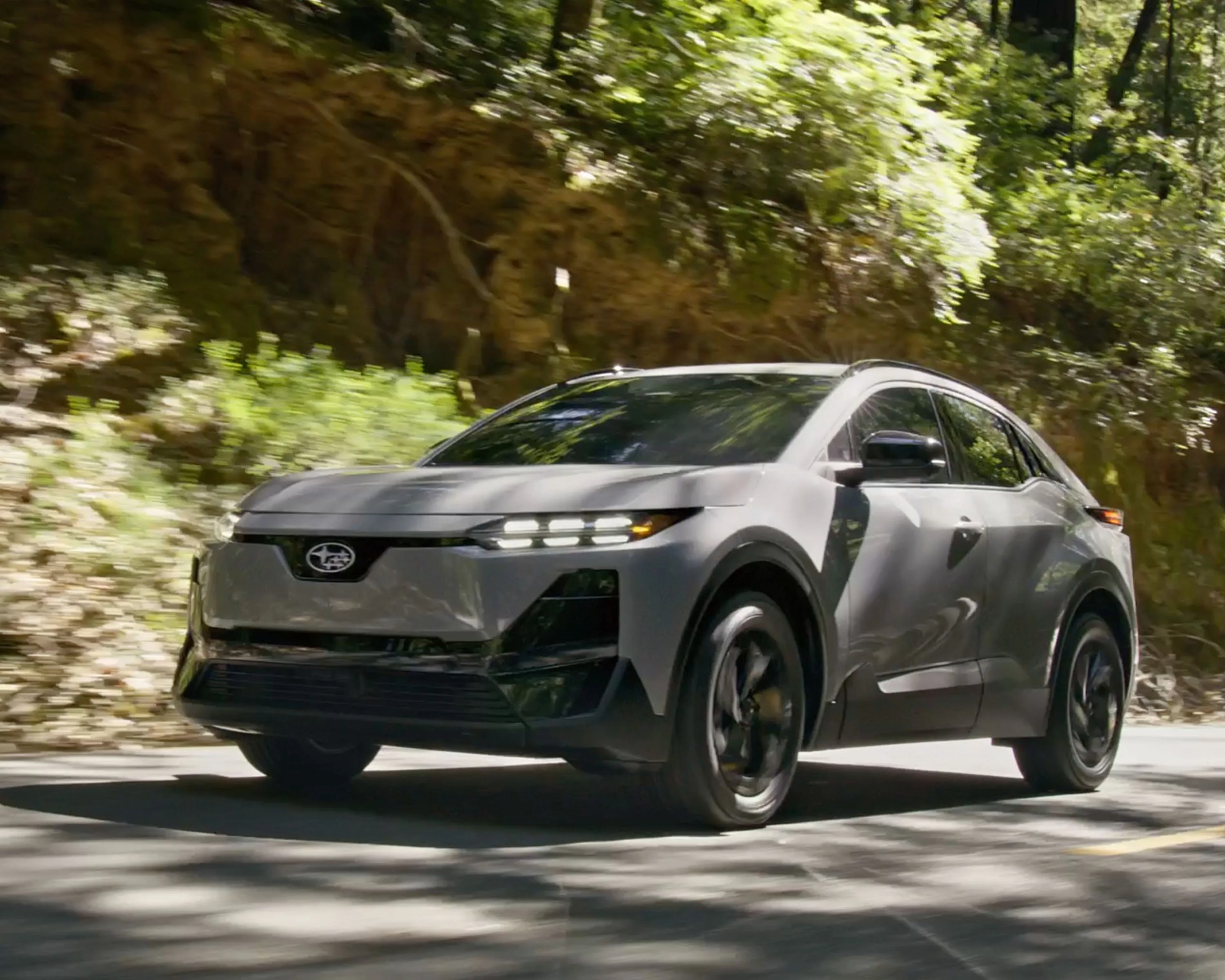 white electric subaru crossover driving
