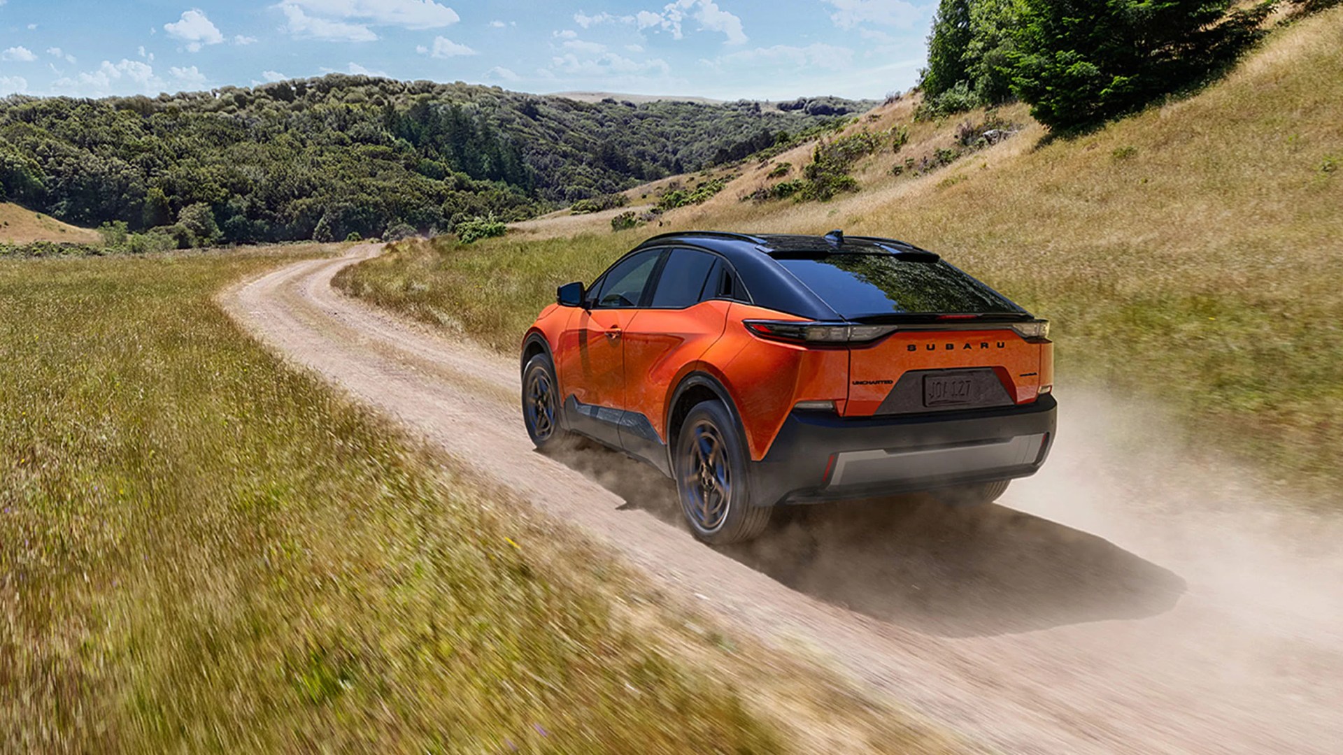 orange subaru electric crossover driving