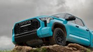 blue toyota pickup perched on rocky ledge