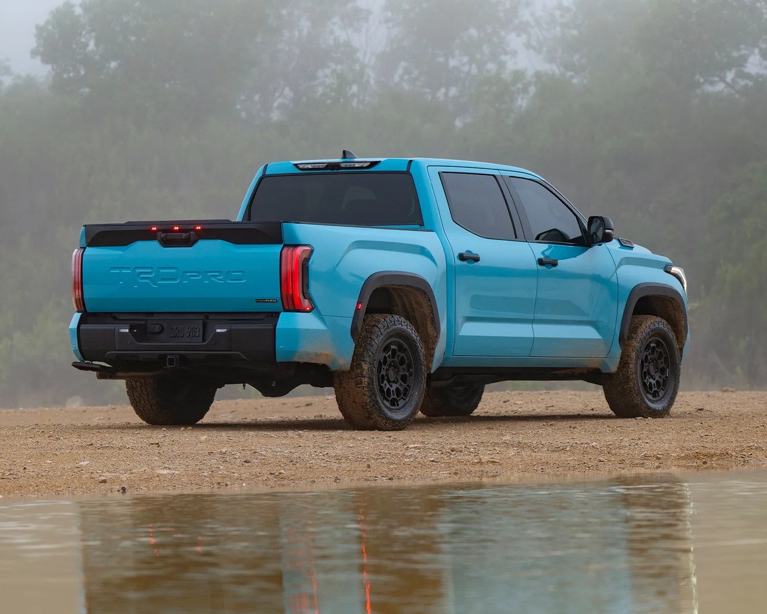 blue toyota pickup rear 3/4 muddy puddle