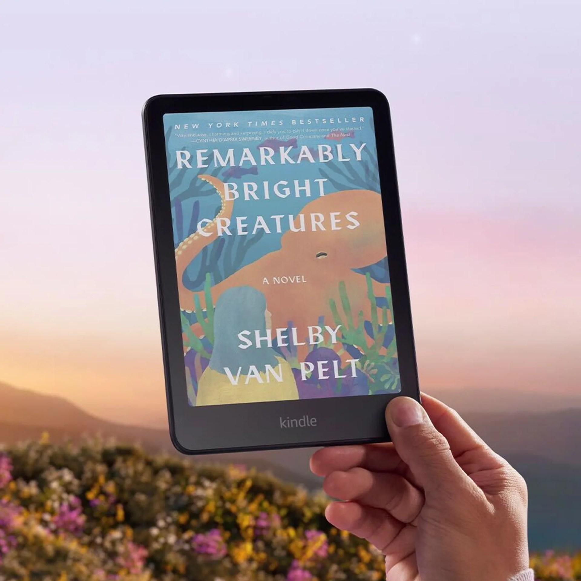 Amazon Kindle Colorsoft in hand outdoors with wildflowers