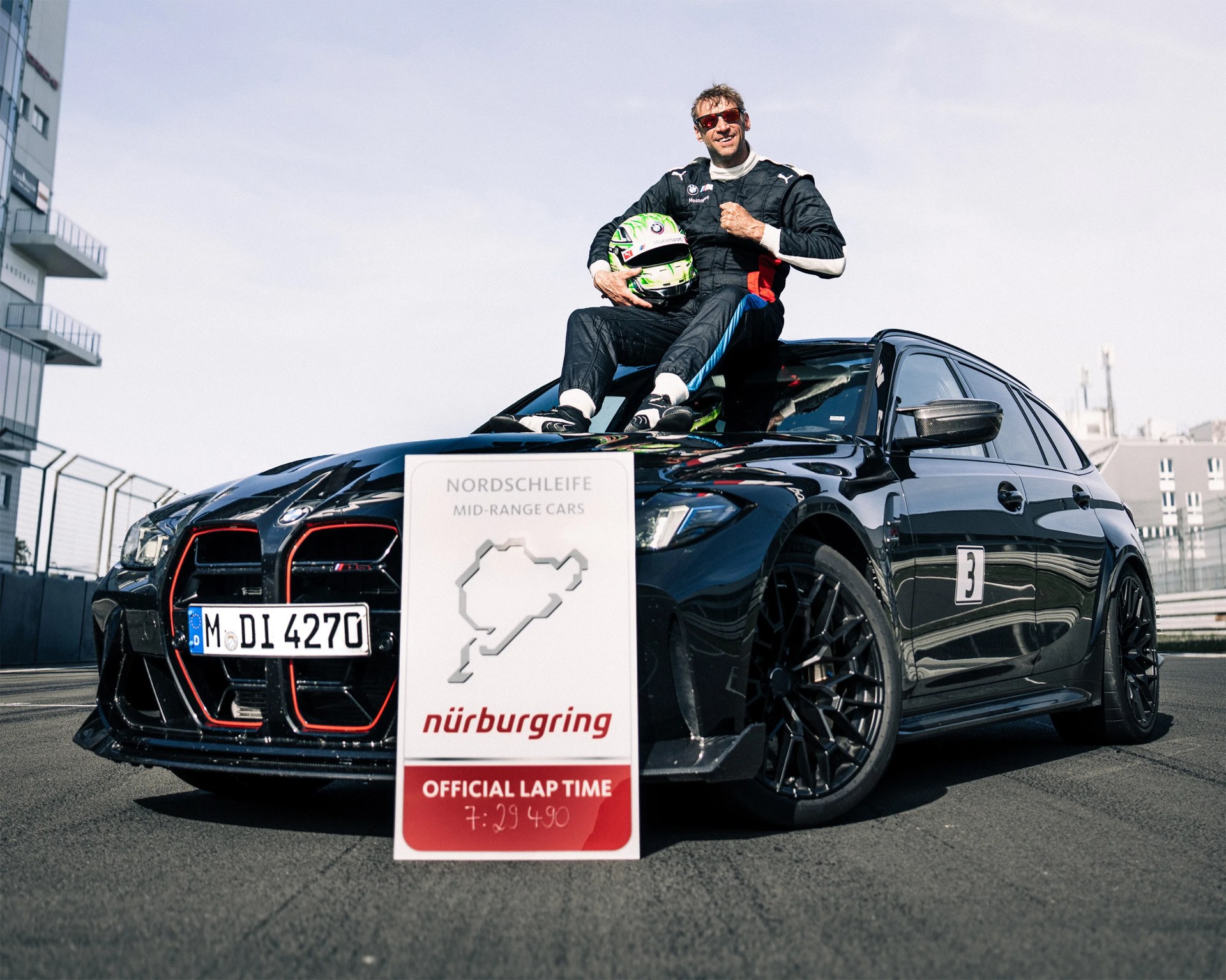 a photo of a BMW station wagon with its record-setting lap time and driver