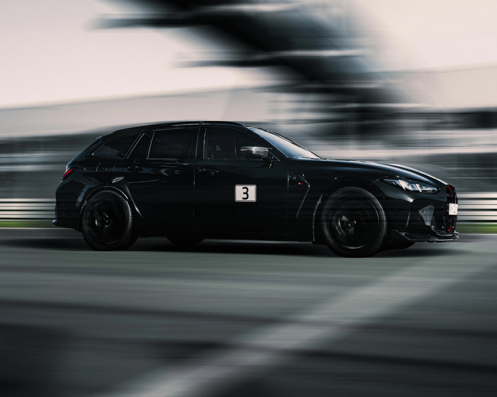 a photo of a bmw station wagon driving on track with blur