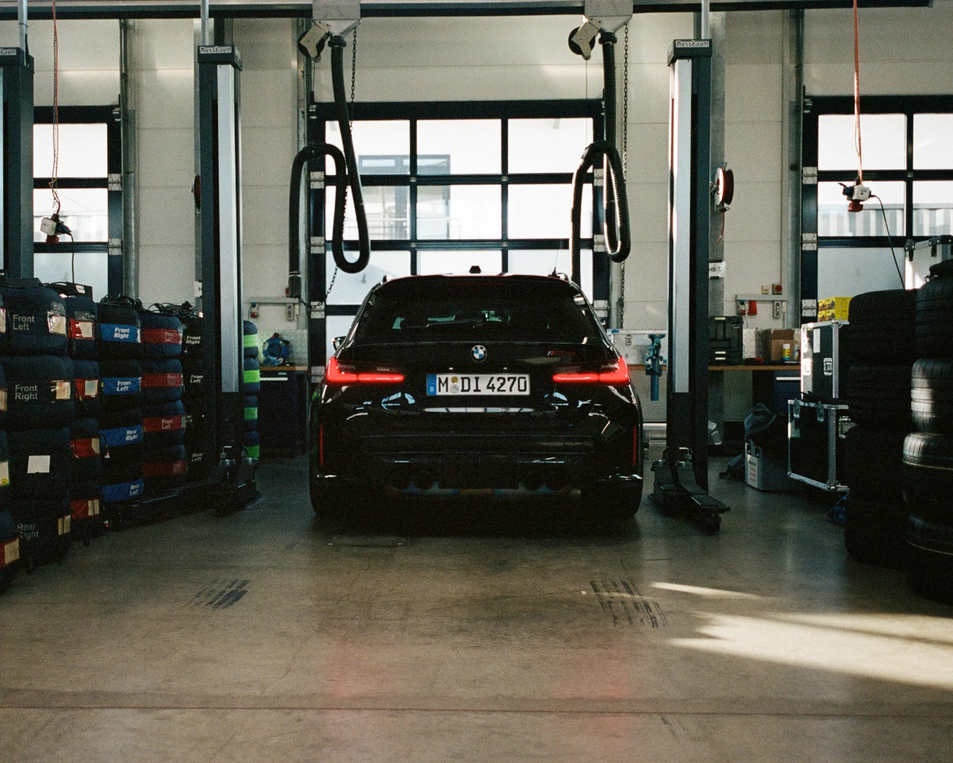 a photo of the rear of a bmw m3 wagon in a garage