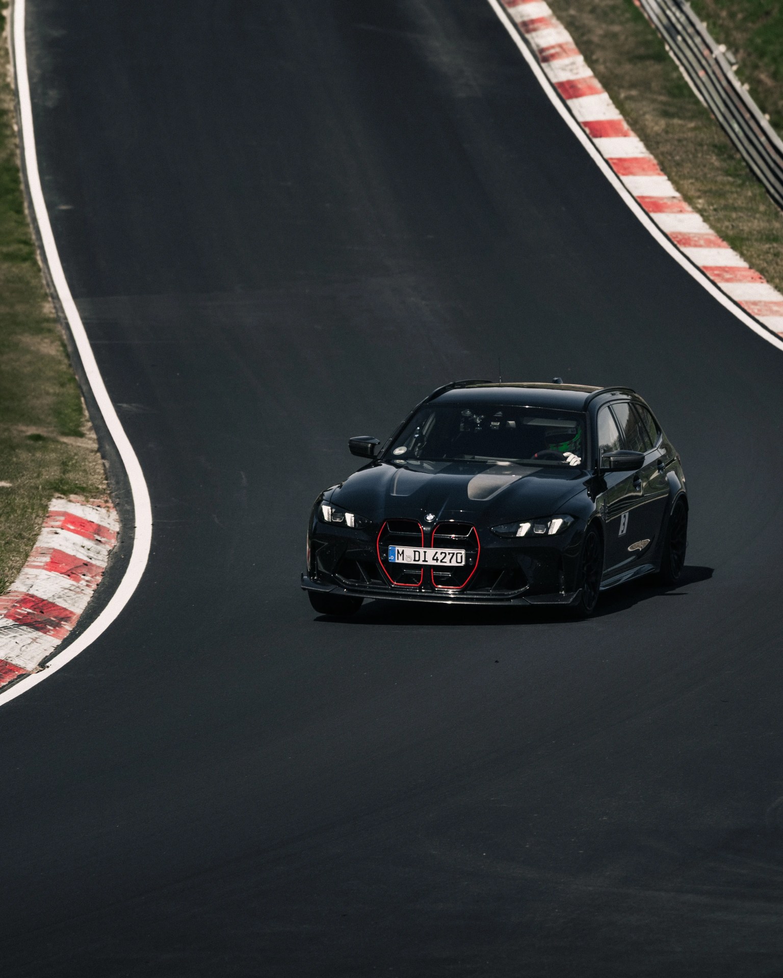 a photo of a BMW station wagon driving on a track