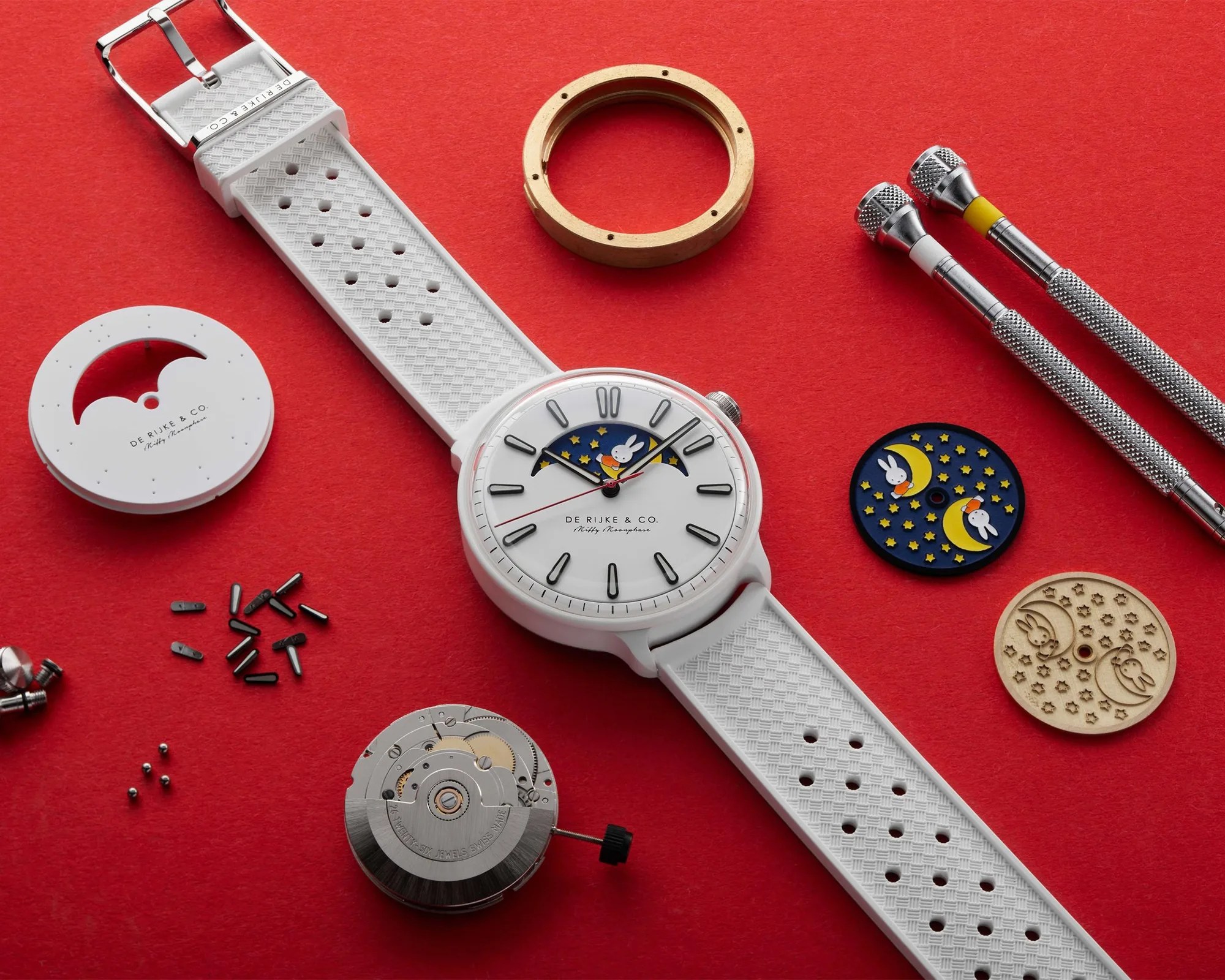 De Rijke & Co. Miffy Moonphase Ceramic Watch next to components on red background
