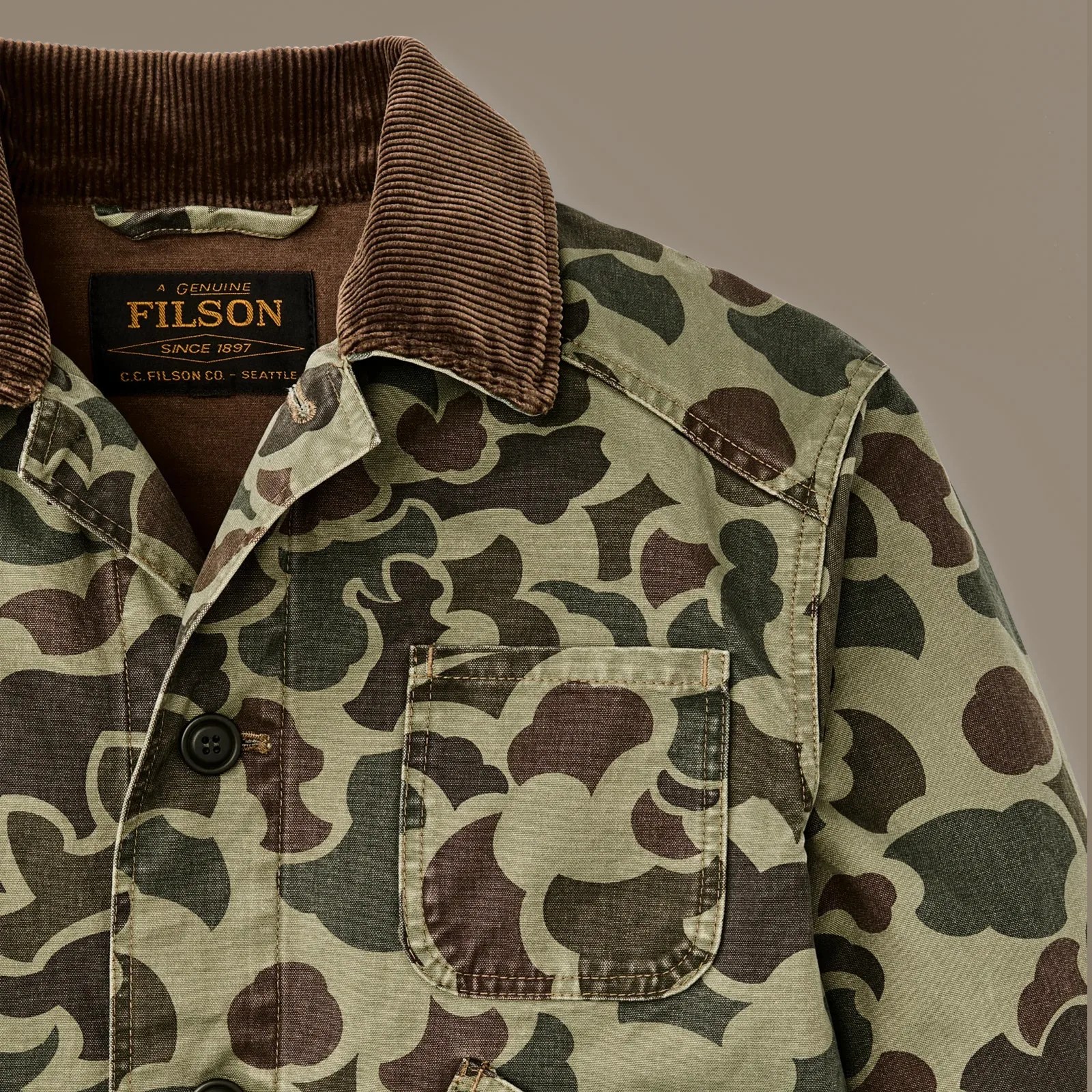 A close-up of the right shoulder of the Filson Canvas Outfitter Jacket in Tundra Camo Shrub