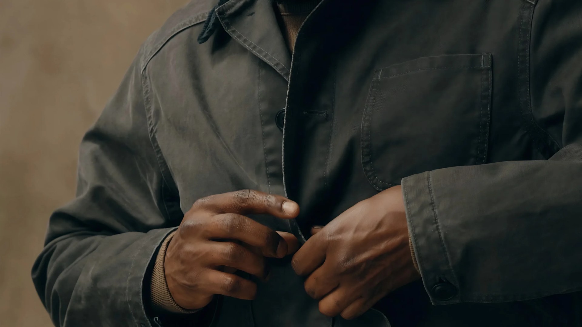 A close-up of the top button and chest area of the Filson Canvas Outfitter Jacket
