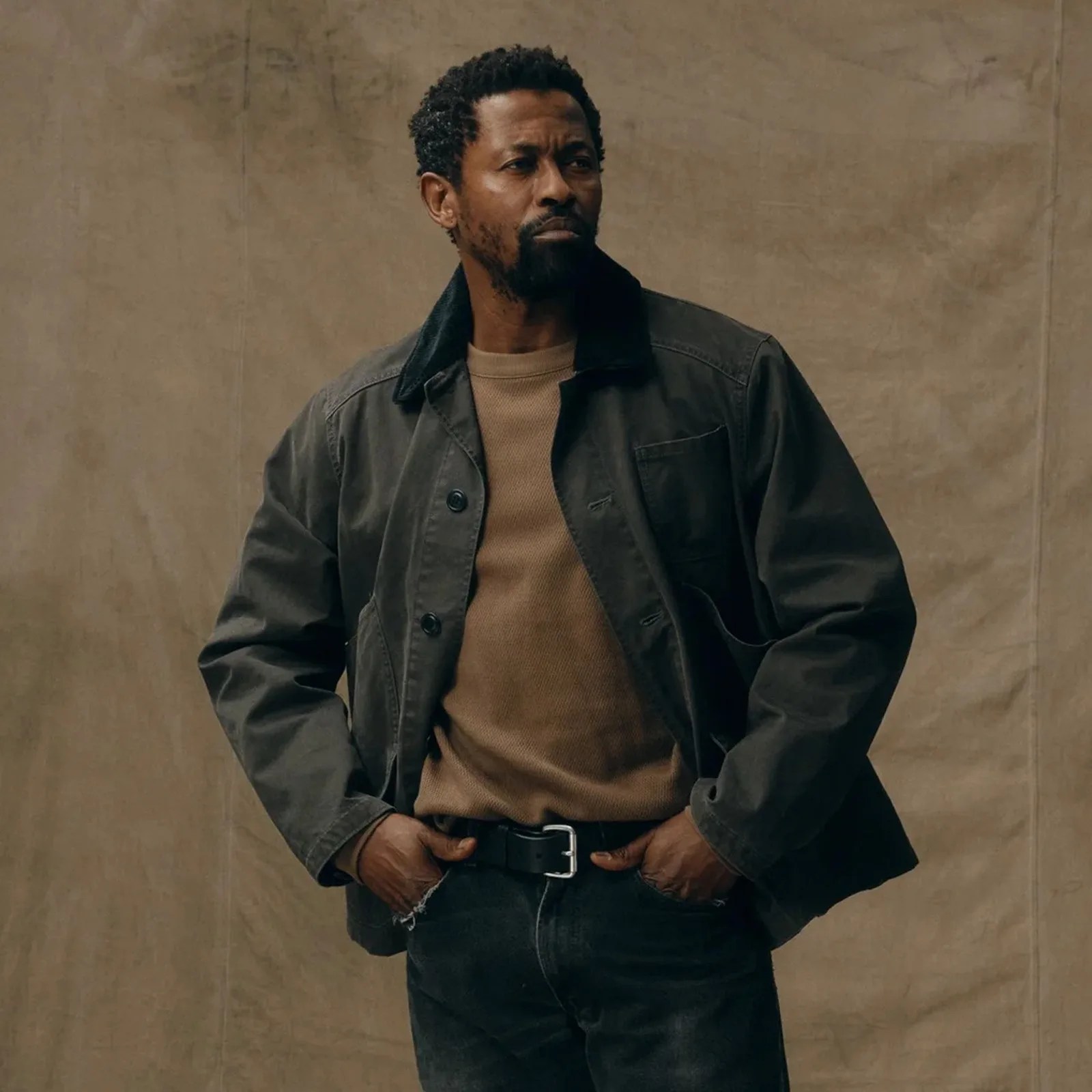 A man shown wearing a Filson Canvas Outfitter Jacket with his hands on his hip
