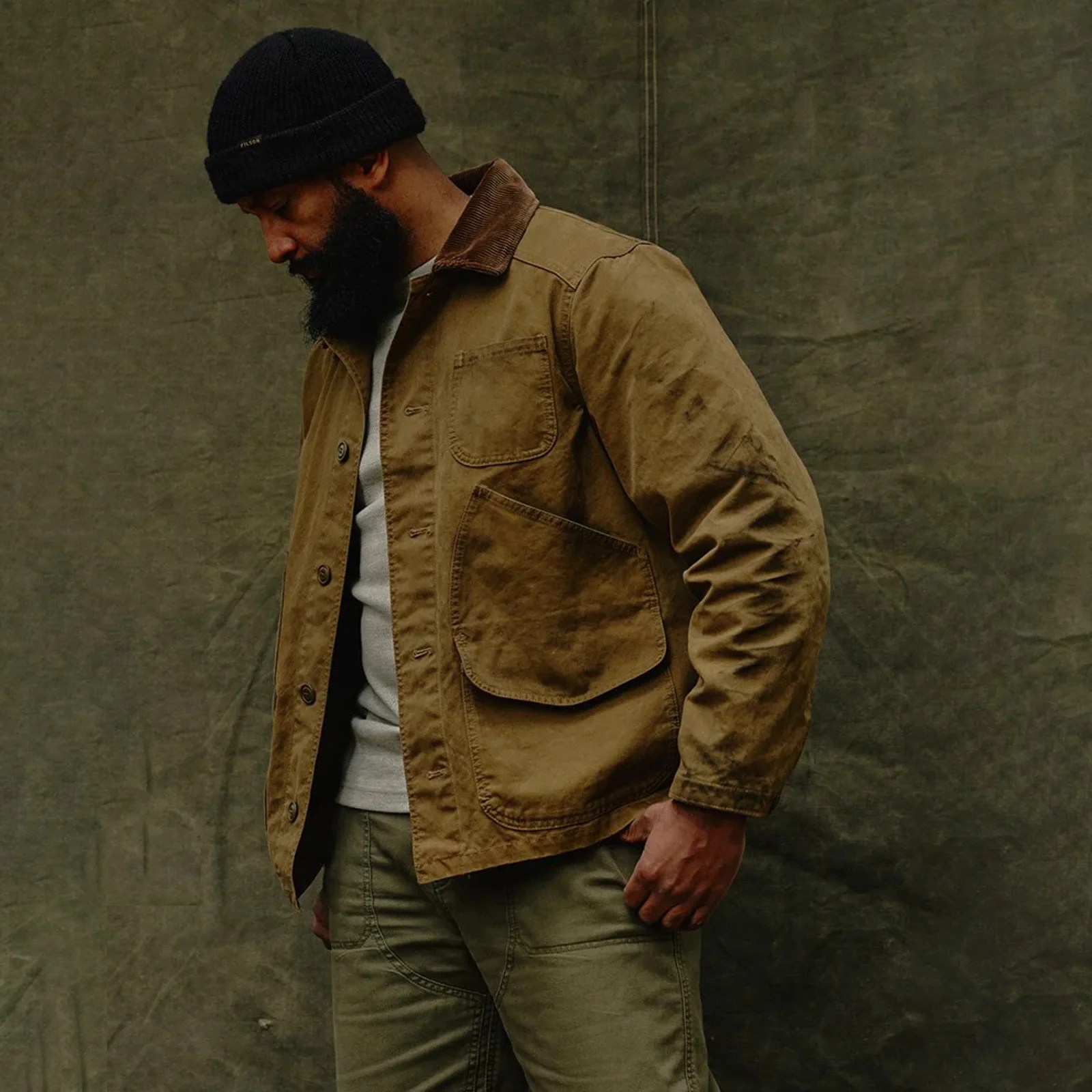 A man wearing a Filson Canvas Outfitter Jacket looking to the side