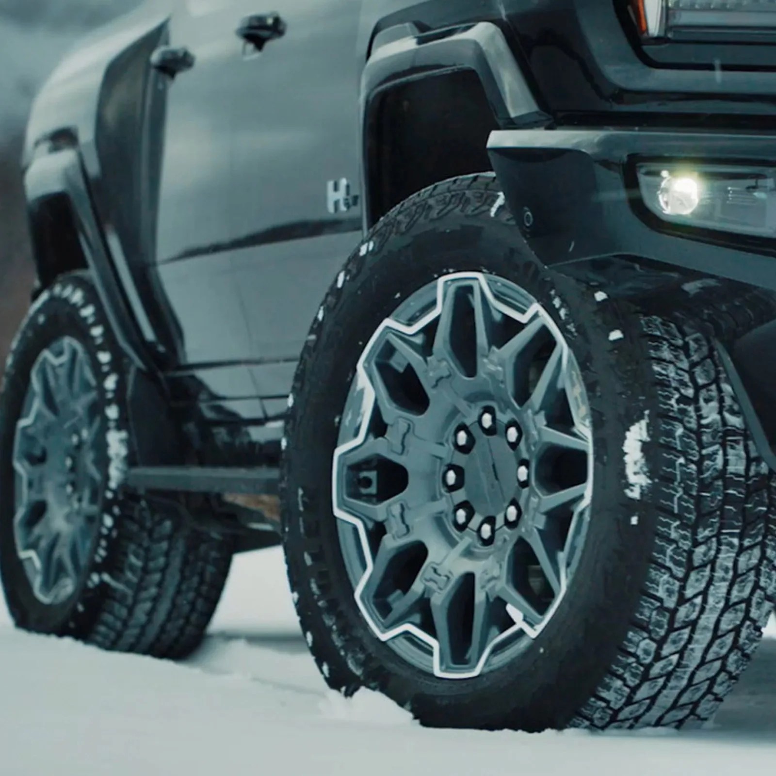 An image of the left side tires on the GMC Hummer EV sitting in snow