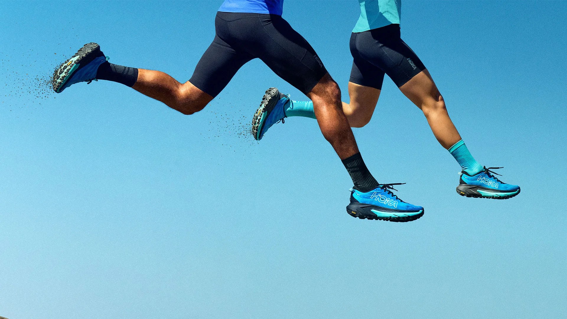 two runners jumping in the sky wearing HOKA Mafate 5