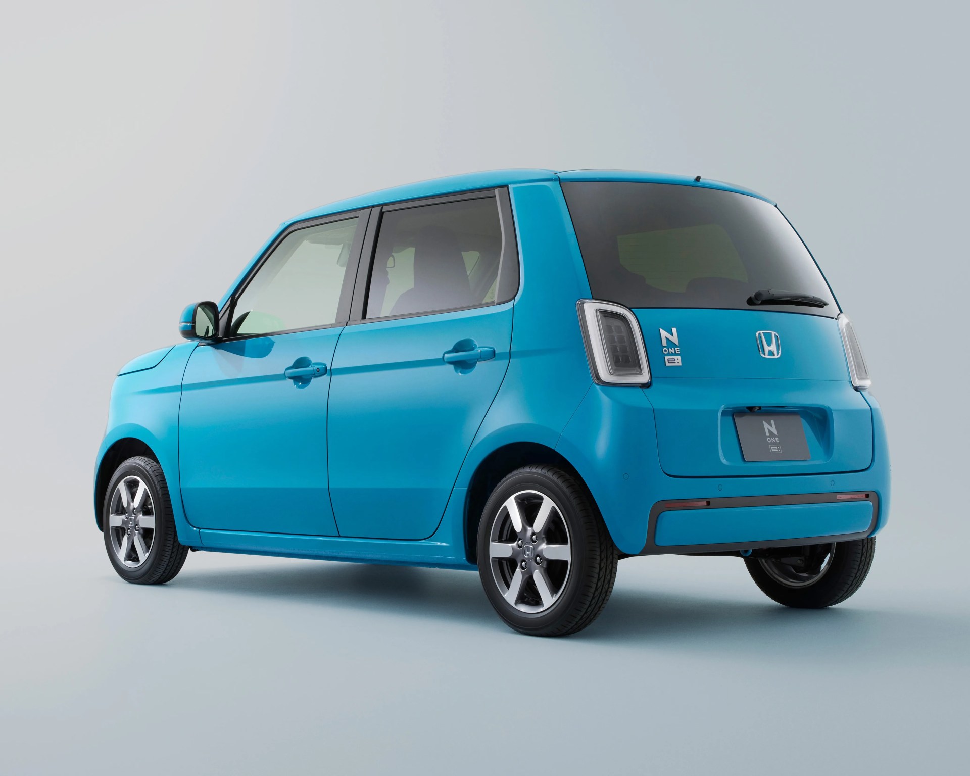 a rear 3/4 photo of a blue honda electric compact