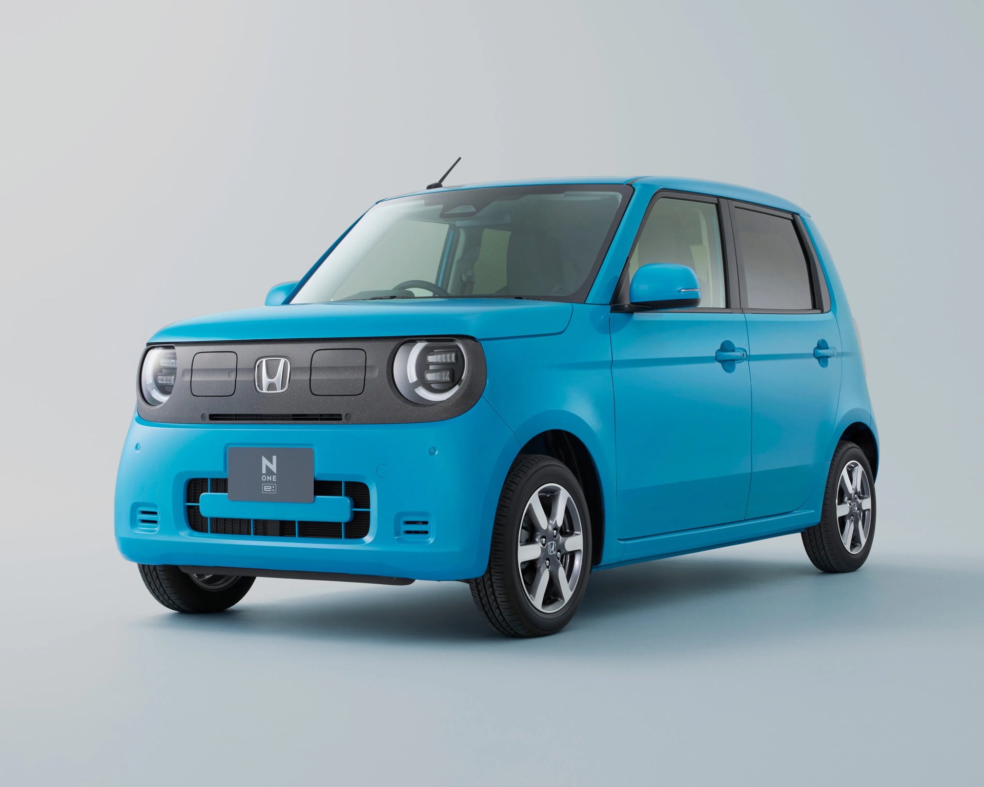 a 3/4 photo of a blue honda electric compact