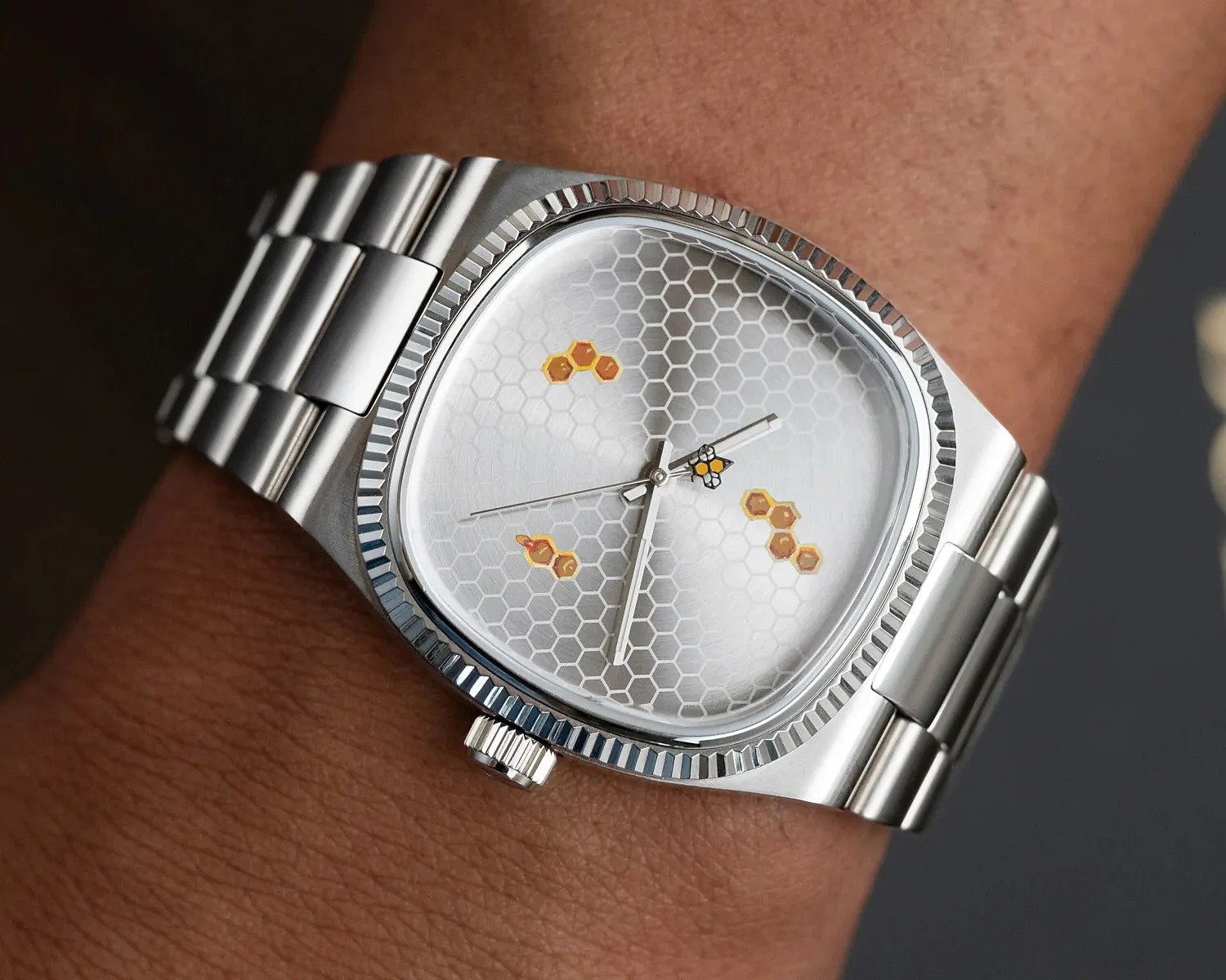 a steel watch with honey comb dial
