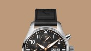 A close-up view of the top half of the IWC Pilot’s Watch Chronograph 41 APXGP against a light tan backgroun