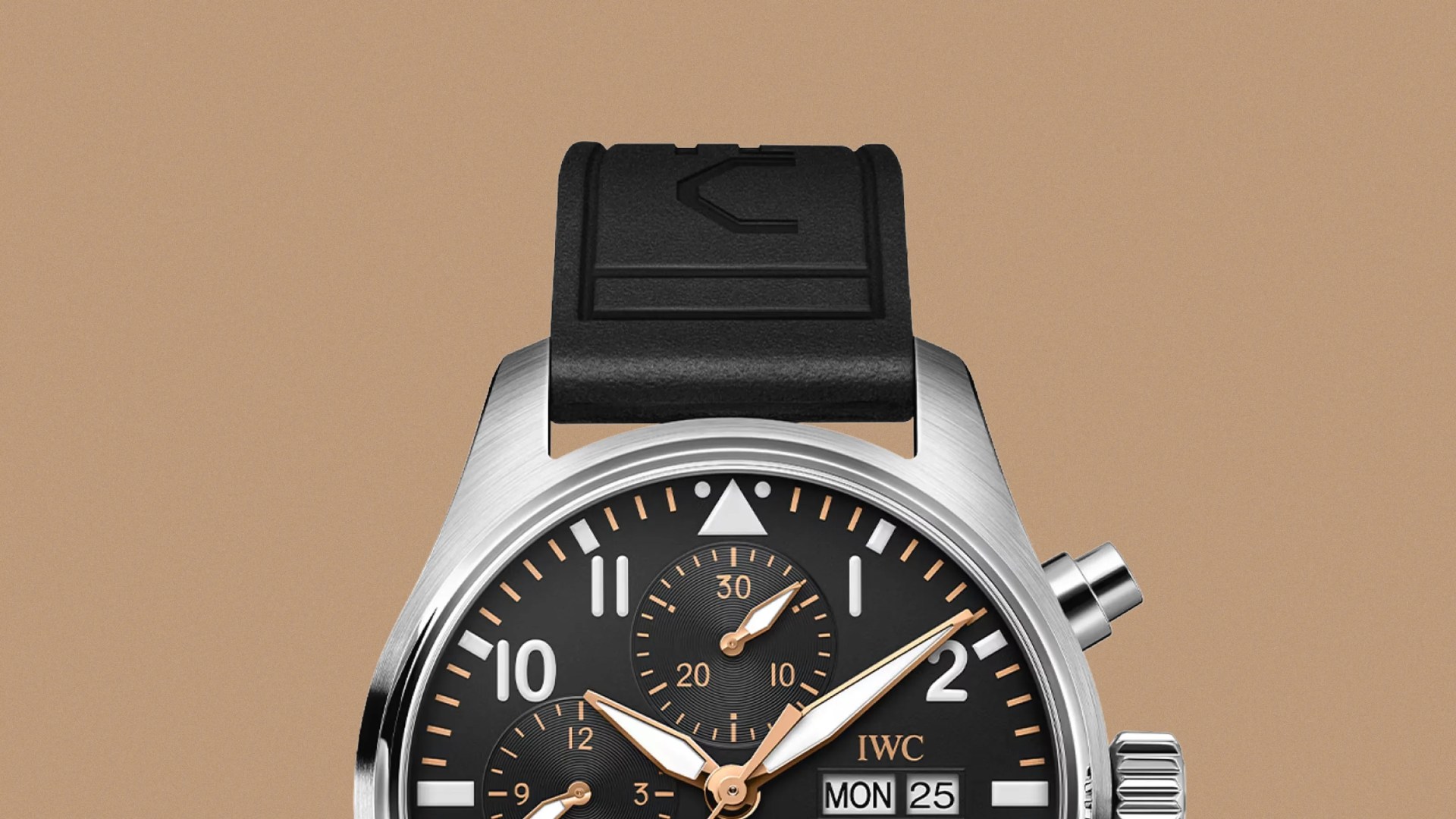 A close-up view of the top half of the IWC Pilot’s Watch Chronograph 41 APXGP against a light tan backgroun