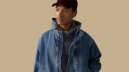 A male model is shown wearing the Levi's Highland Park Denim Jacket, looking to the right against a light tan background.