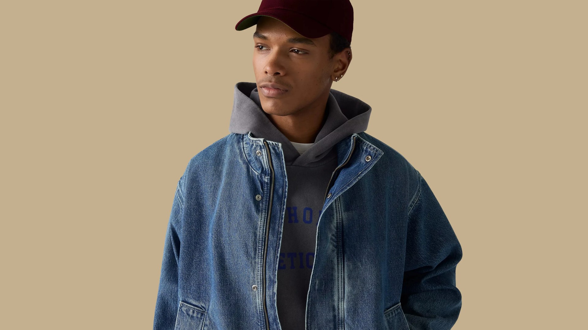 A male model is shown wearing the Levi's Highland Park Denim Jacket, looking to the right against a light tan background.