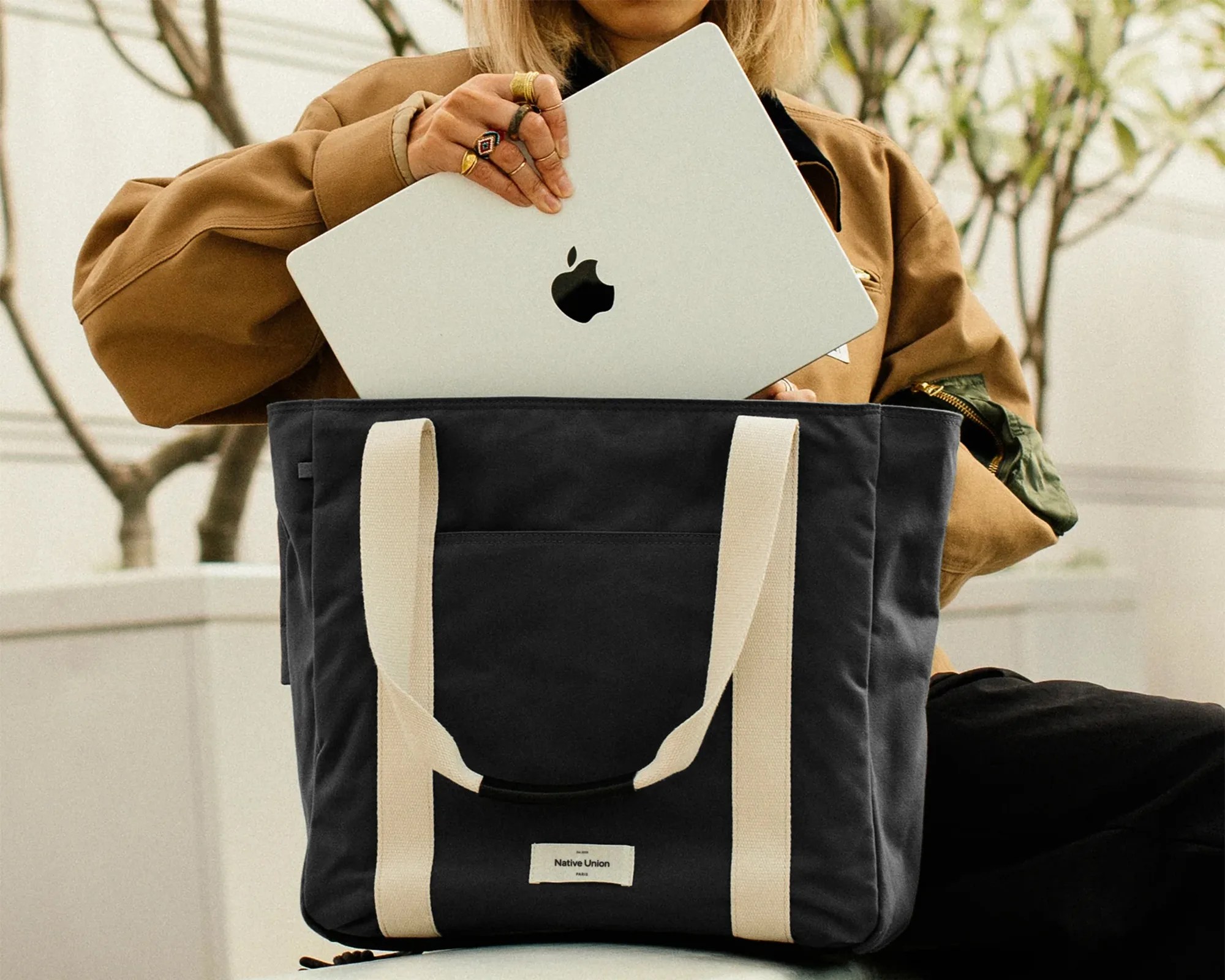 Native Union WFA EDC tote with person putting Apple laptop inside