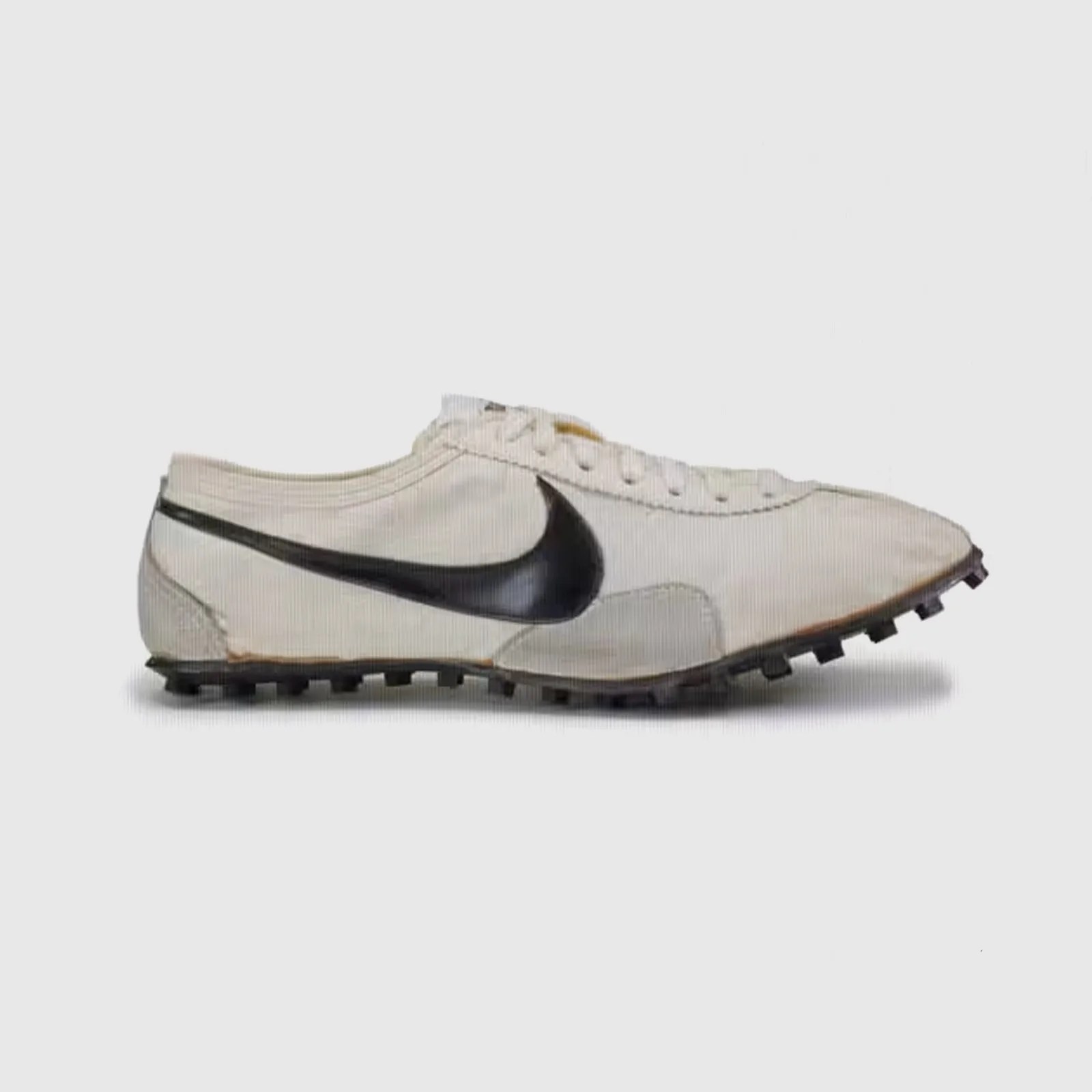 A signal example of Nike's first running shoe, a.k.a the Waffle Racer or "Moon Shoe" shown in profile with the toe facing to the right of the image frame against a light grey background