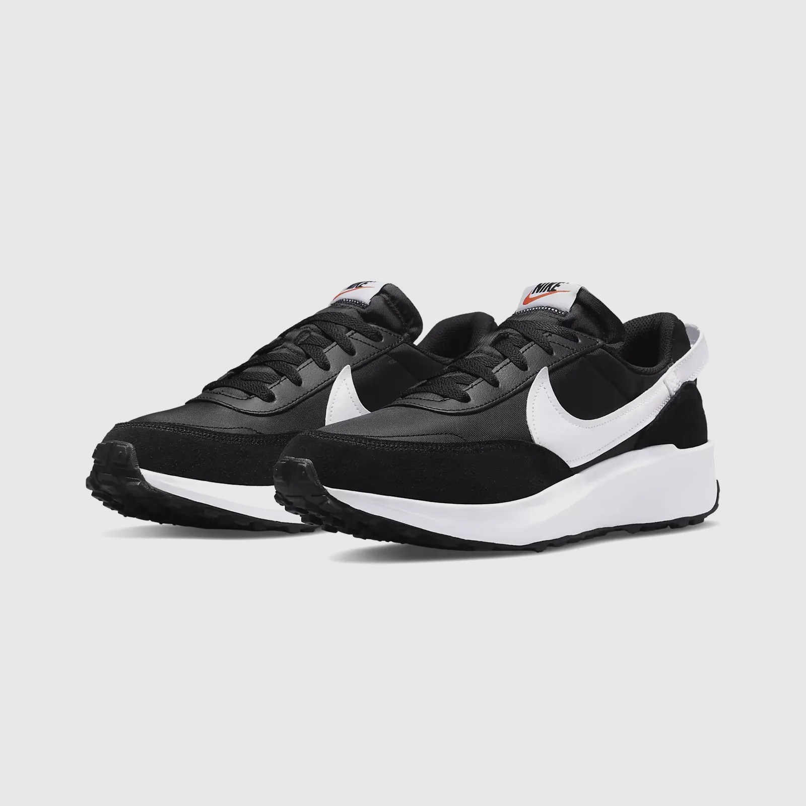 A pair of Nike Waffle Debut sneakers in black shown at an angle