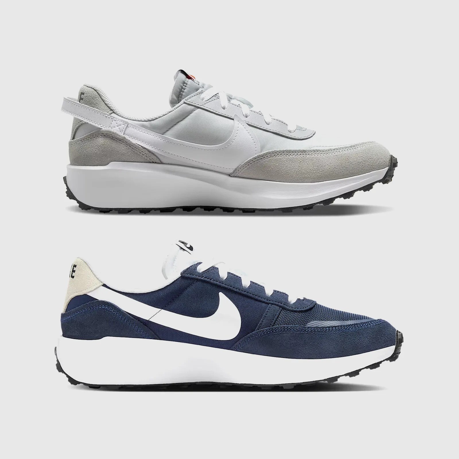 A single Nike Waffle Nav and Waffle Debut are shown in profile, with the toes facing the right of the image frame stacked vertically but not touching, and shown against a grey background