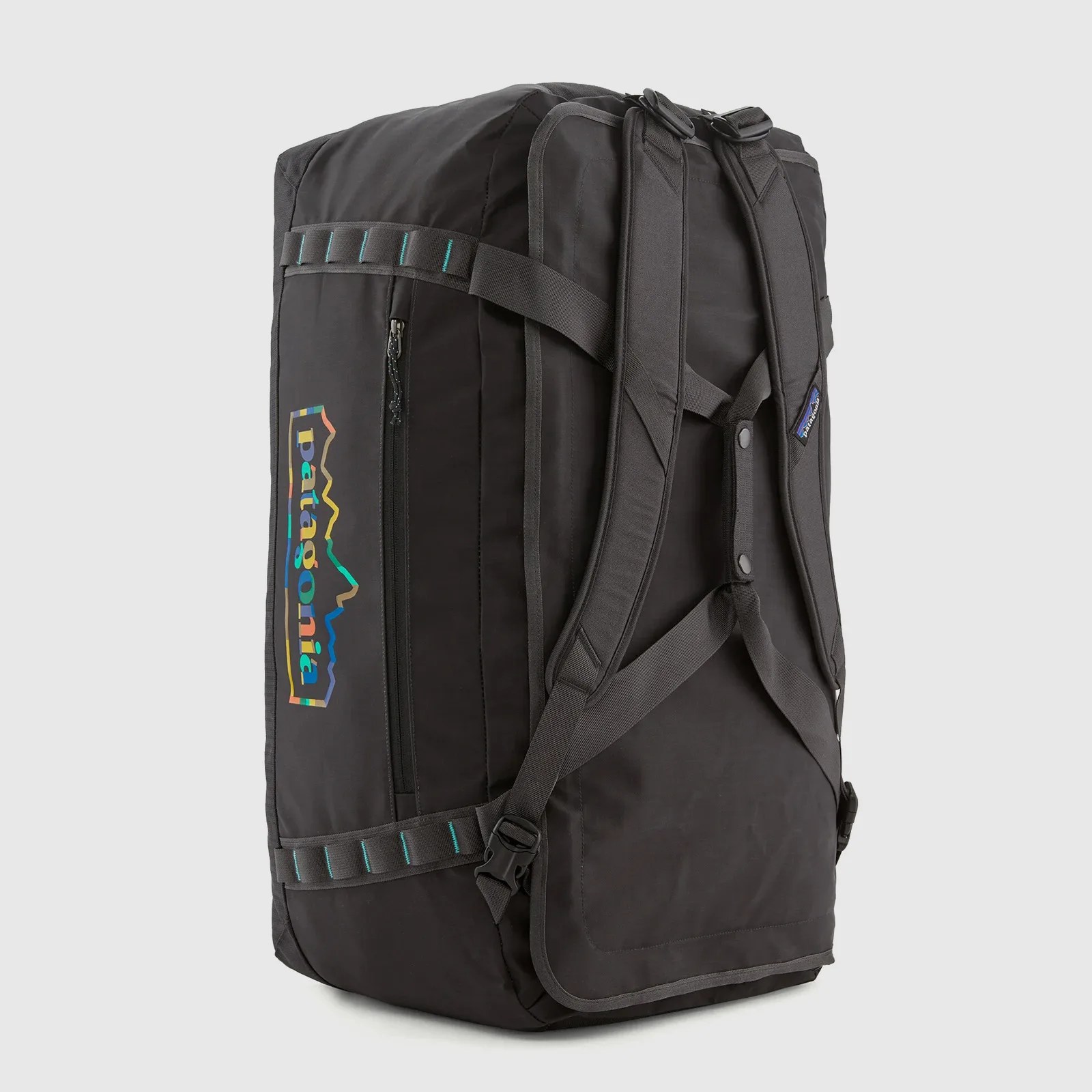 A Patagonia Black Hole duffle bag in black shown standing on one end with its backpack straps