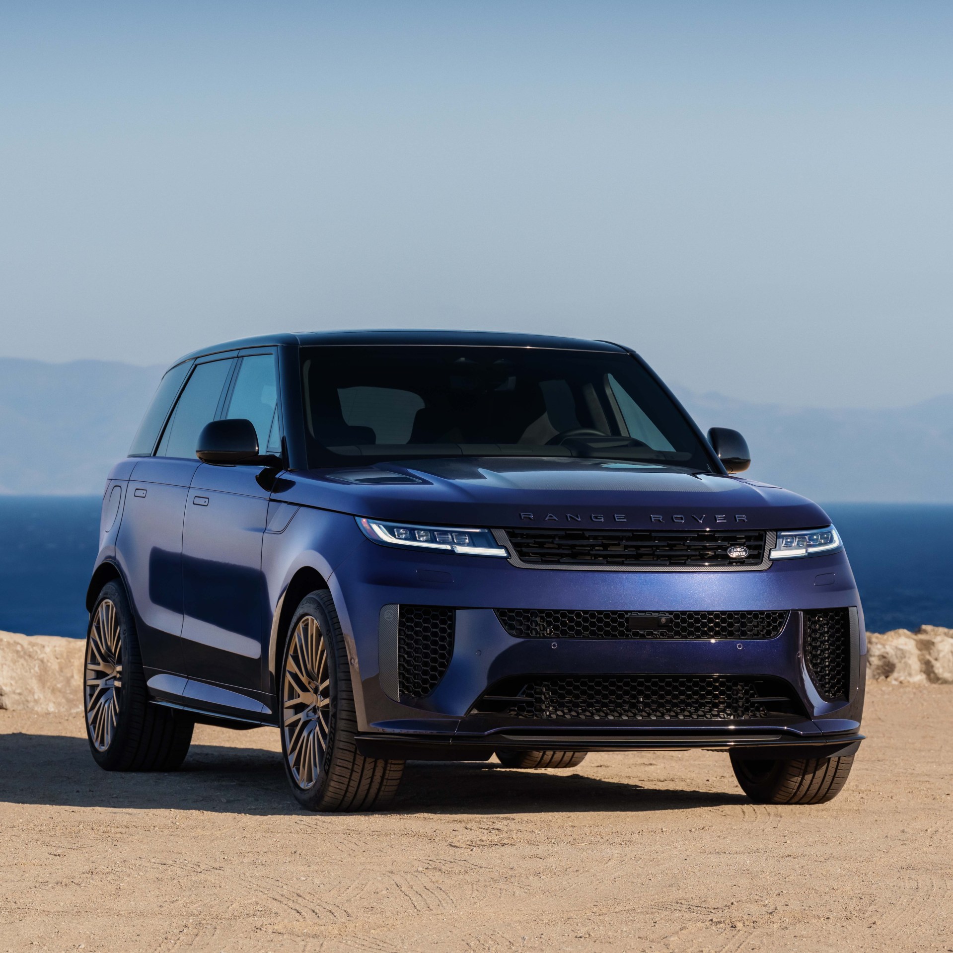 blue range rover sport parked on light gravel
