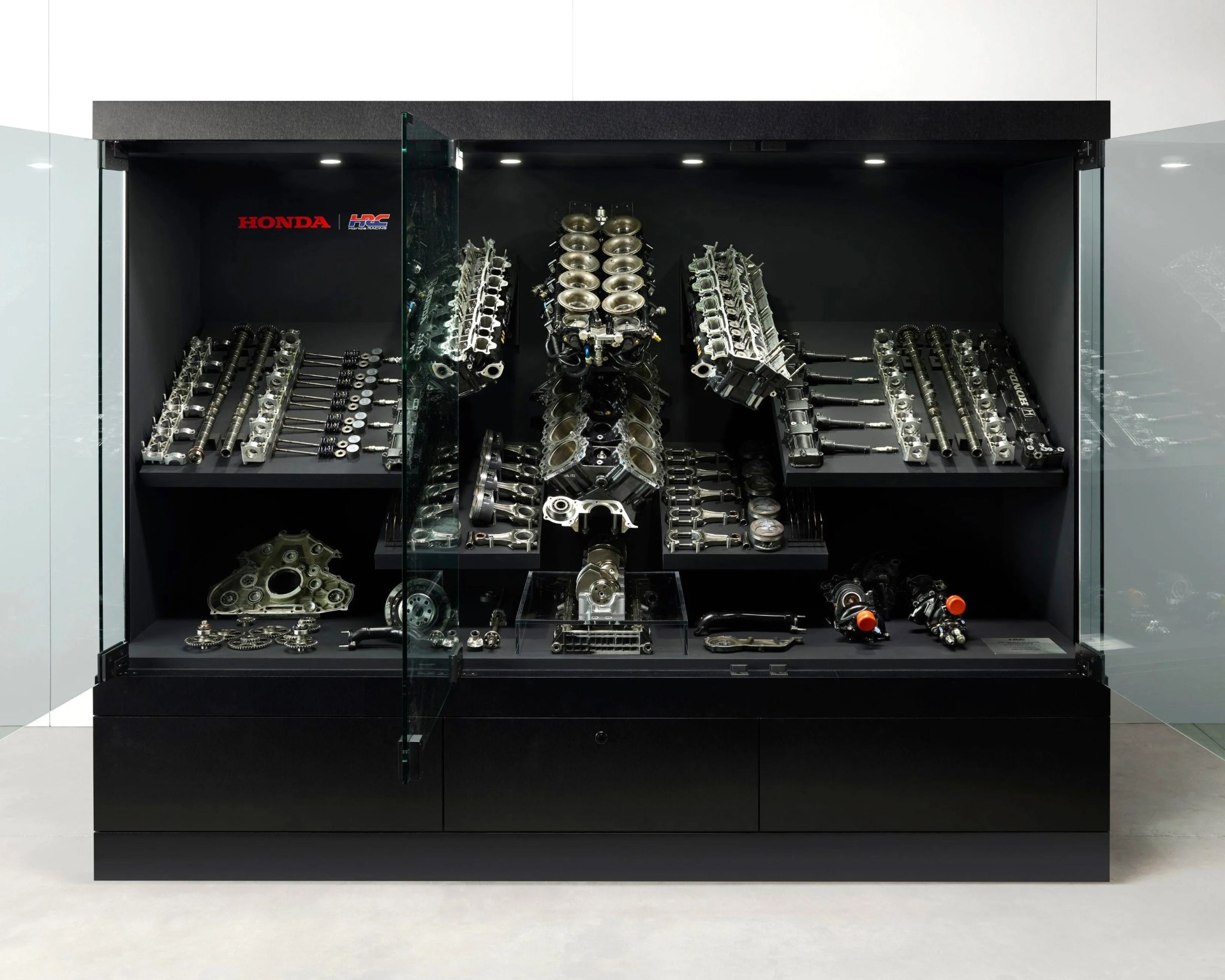 a display case showing a disassembled honda formula one engine