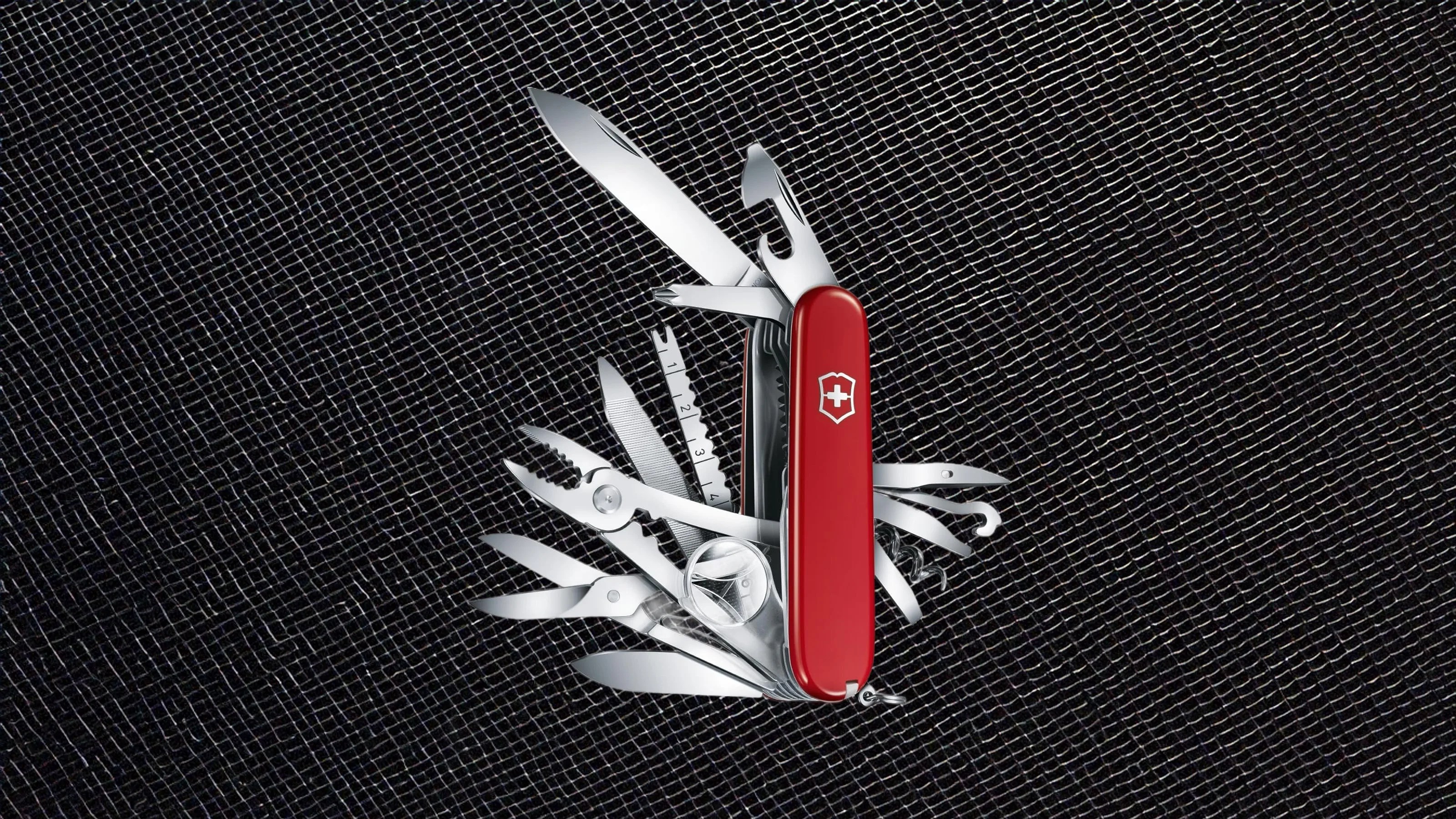 This Swiss Army Knife Camp multi-tool shown fully open against a metallic black wire background