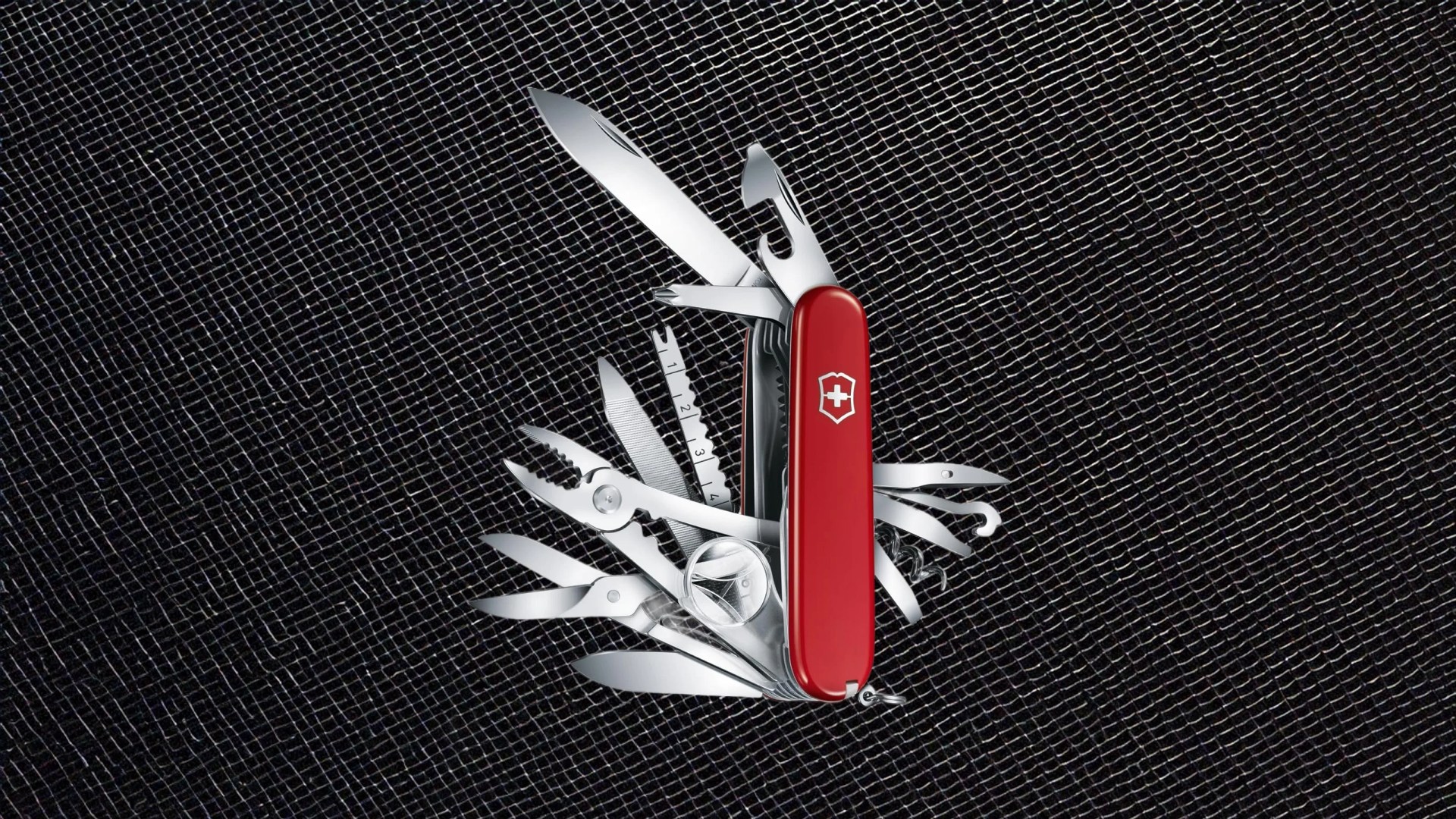 This Swiss Army Knife Camp multi-tool shown fully open against a metallic black wire background