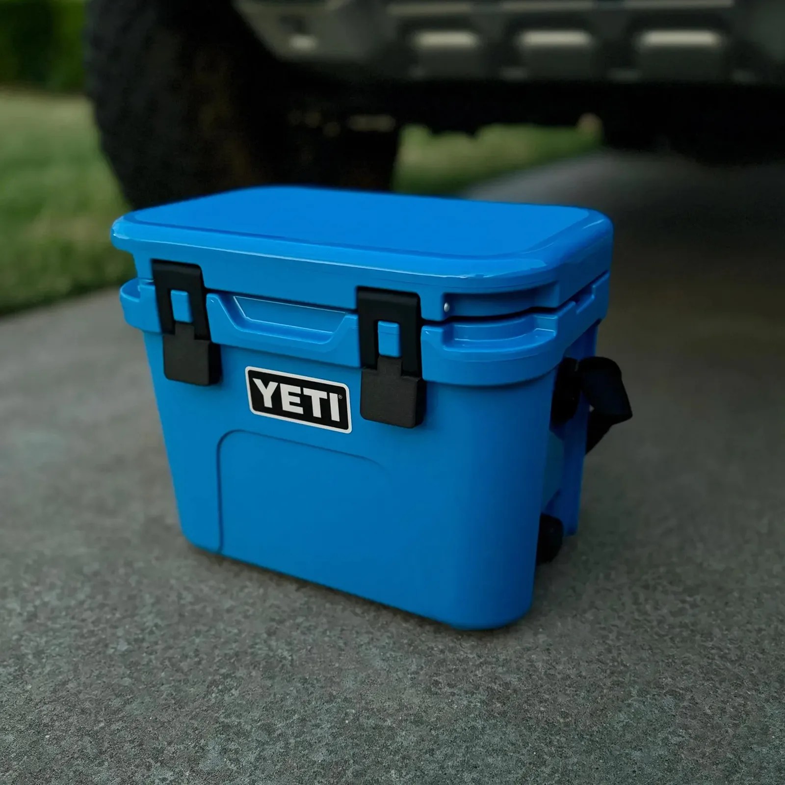 A pair of Latch Outdoors latch accessories shown closed on a blue Yeti Roadie cooler